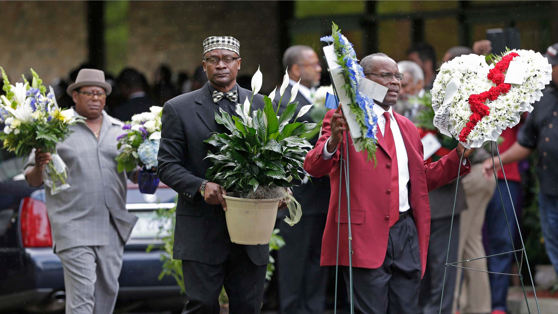 April 11, 2015: Men carry flowers into the World Outreach Revival Deliverance Ministries Christian Center before the funeral service in Summerville, S.C.,