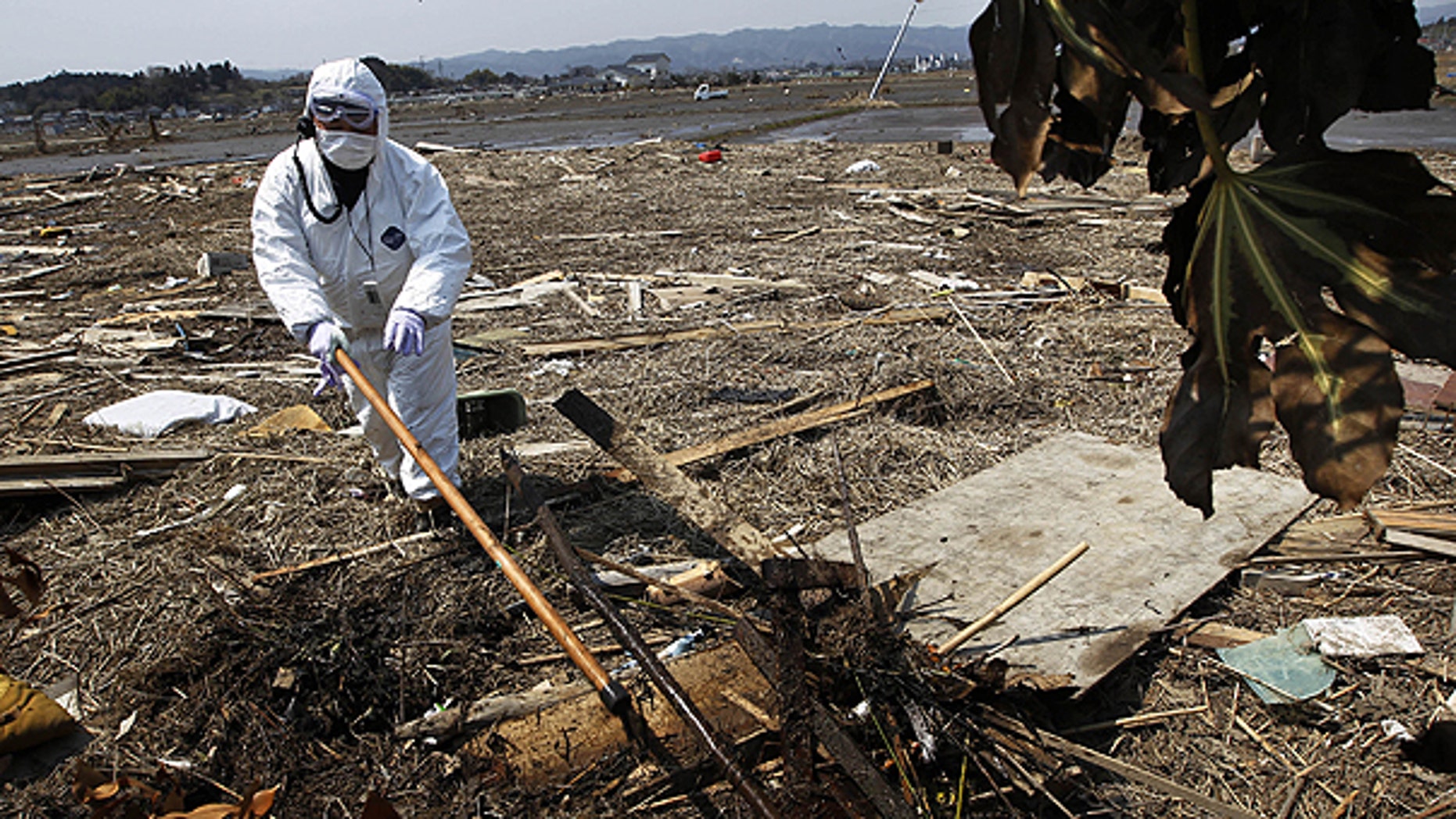 April 13: A police officer in protective suit searches for missing people in Minami Soma, Fukushima Prefecture, northeastern Japan.