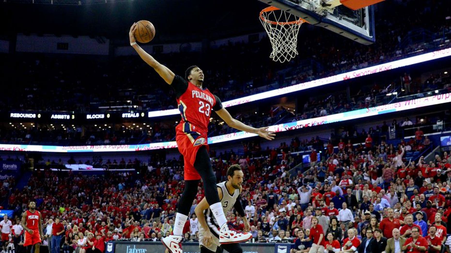 Apr 15, 2015; New Orleans, LA, USA; New Orleans Pelicans forward Anthony Davis (23) dunks over San Antonio Spurs forward Marco Belinelli (3) during the first quarter of a game at the Smoothie King Center. Mandatory Credit: Derick E. Hingle-USA TODAY Sports
