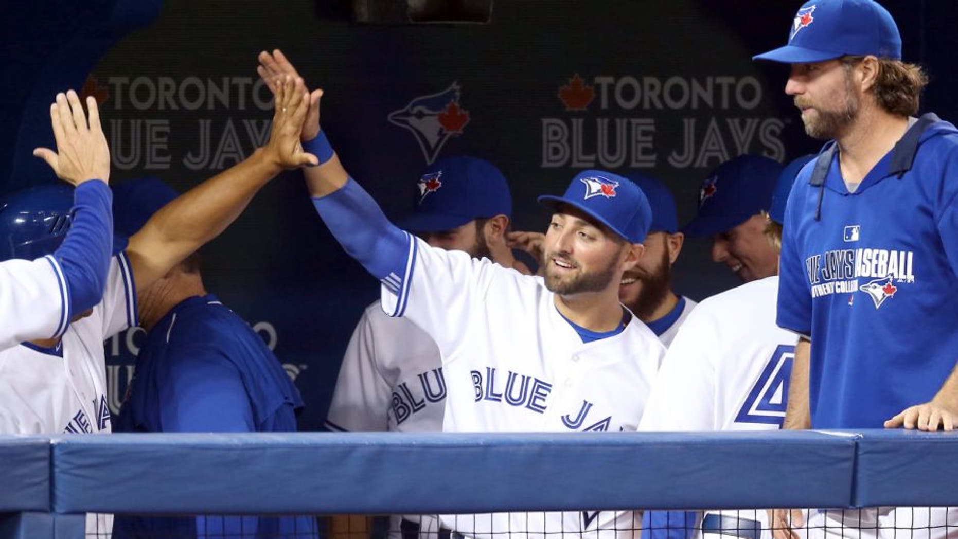 TORONTO, CANADA - APRIL 15: Kevin Pillar #11 of the Toronto Blue Jays is congratulated by teammates after making a leaping catch in the seventh inning during an MLB game against the Tampa Bay Rays on April 15, 2015 at Rogers Centre in Toronto, Ontario, Canada. All uniformed team members are wearing jersey number 42 in honor of Jackie Robinson Day. (Photo by Tom Szczerbowski/Getty Images)