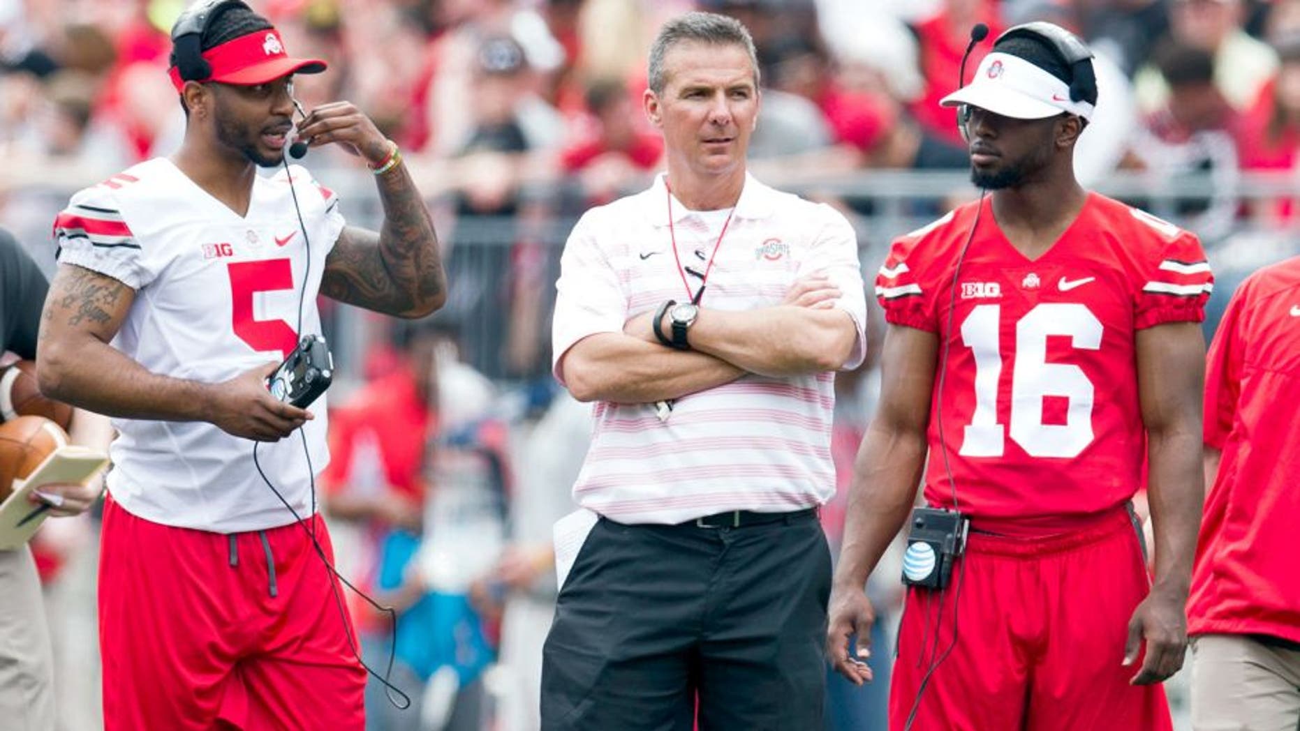 Apr 18, 2015; Columbus, OH, USA; Ohio State Buckeyes quarterback Braxton Miller (5) head coach Urban Meyer and quarterback J.T. Barrett (16) talk on the field during the Ohio State Spring Game at Ohio Stadium. The Gray team won the game 17-14. Mandatory Credit: Greg Bartram-USA TODAY Sports