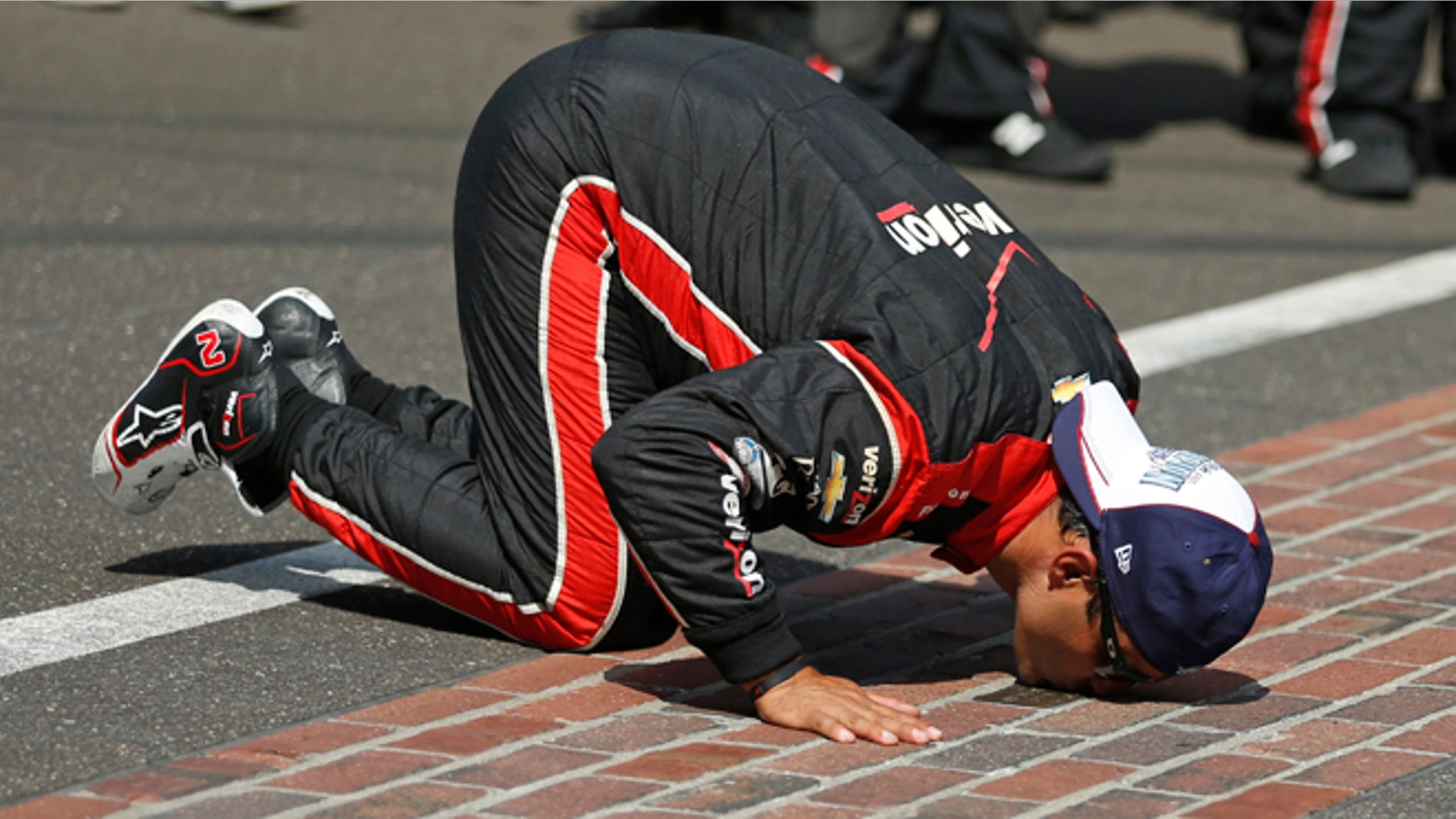 Juan Pablo Montoya, of Colombia, kisses the start/finish line after winning the 99th running of the Indianapolis 500 auto race at Indianapolis Motor Speedway in Indianapolis, Sunday, May 24, 2015. (AP Photo/Rob Baker)