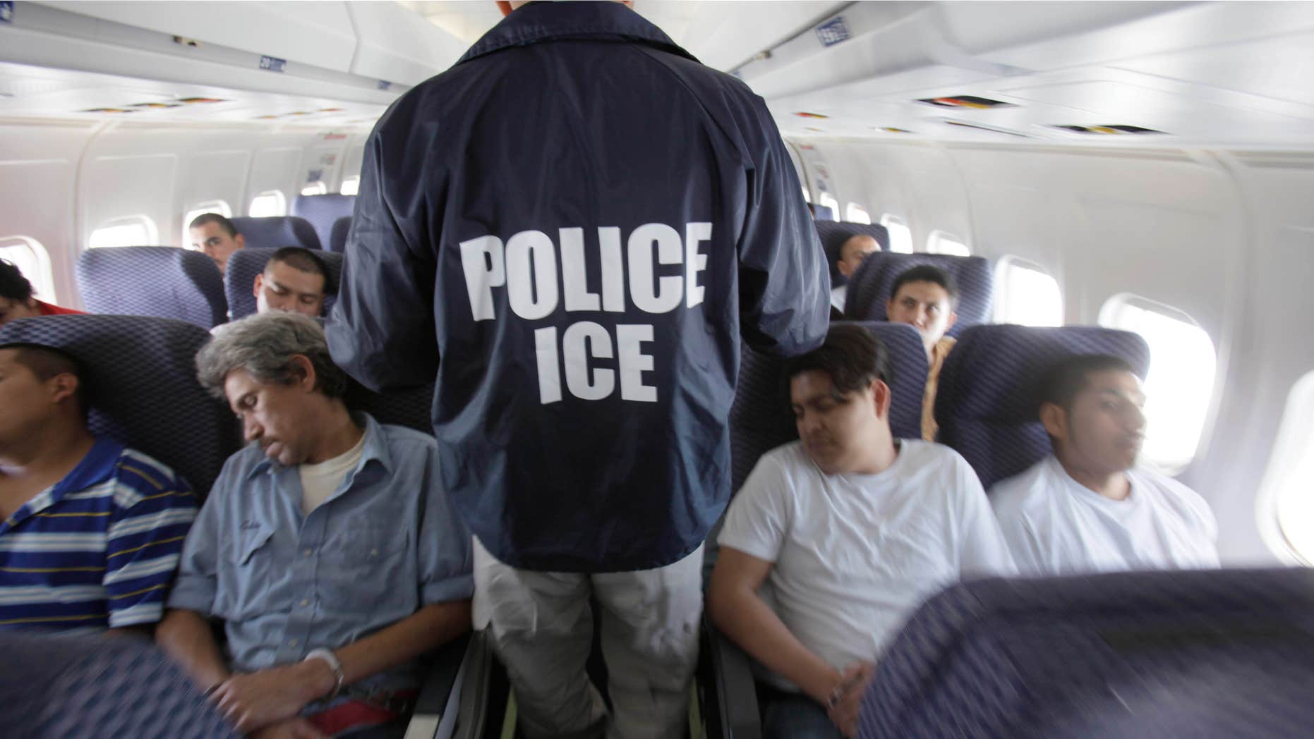 May 25, 2010: An Immigration and Customs Enforcement agent walks down the aisle among shackled Mexican immigrants a boarded a U.S. Immigration and Customs Enforcement charter jet for deportation in the air between Chicago, Il.