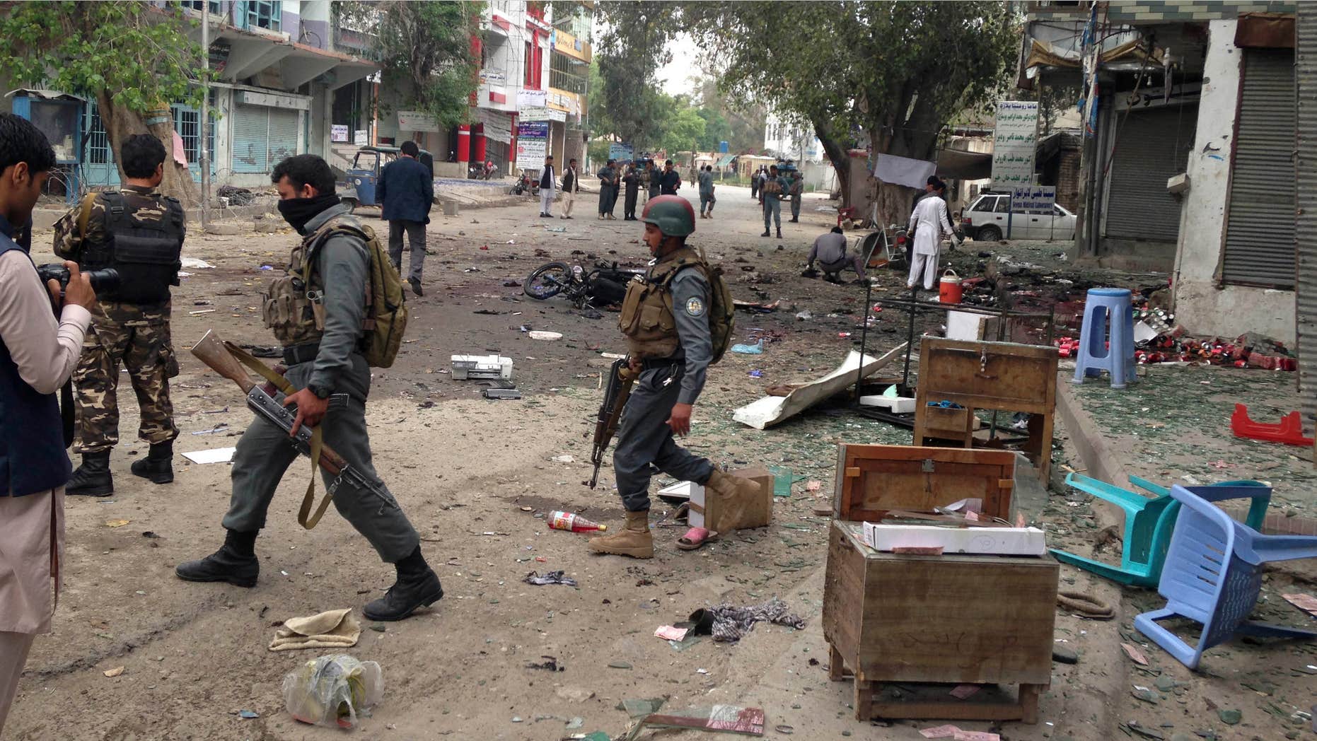 April 18, 2015: Afghan security forces members inspect the site of a suicide attack near a new Kabul Bank in Jalalabad, east of Kabul, Afghanistan.
