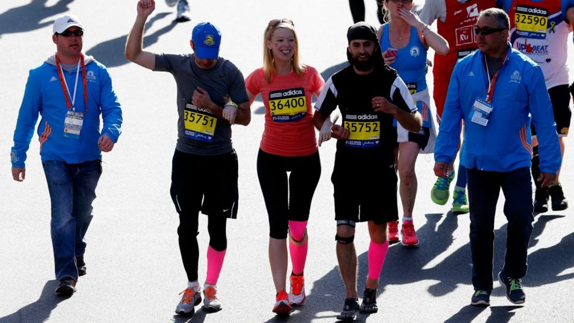 cross the finish line of the 118th Boston Marathon on April 21, 2014 in Boston, Massachusetts.