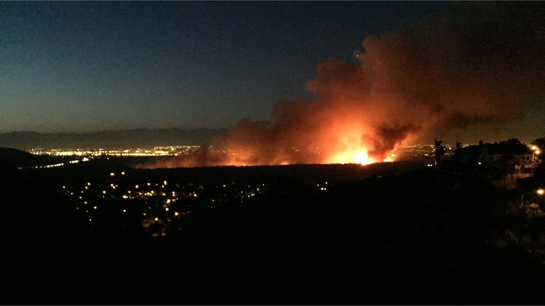 April 18, 2015: A brush fire burns in the Dam Prado Dam Flood Control Basin north of the city of Corona, Calif.