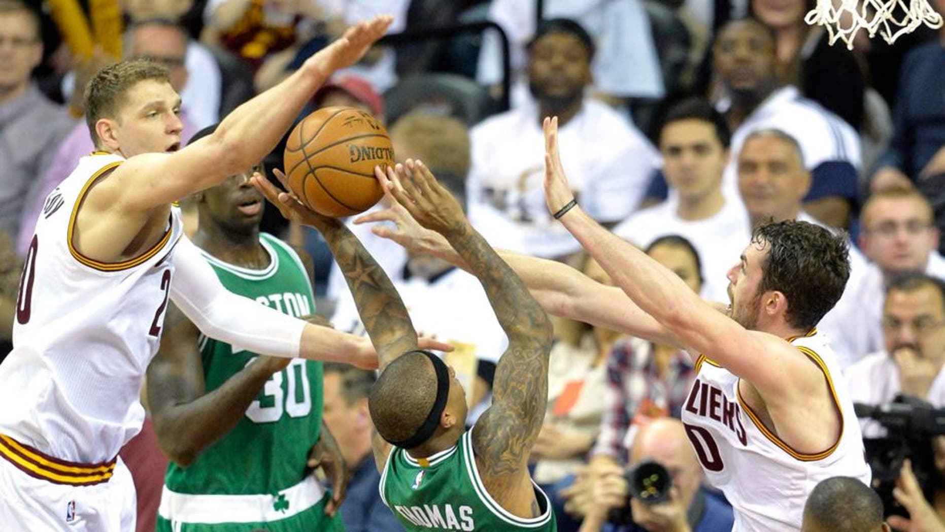 Apr 19, 2015; Cleveland, OH, USA; Boston Celtics guard Isaiah Thomas (4) drives between Cleveland Cavaliers center Timofey Mozgov (20) and forward Kevin Love (0) in the third quarter in game one of the first round of the NBA Playoffs at Quicken Loans Arena. Mandatory Credit: David Richard-USA TODAY Sports