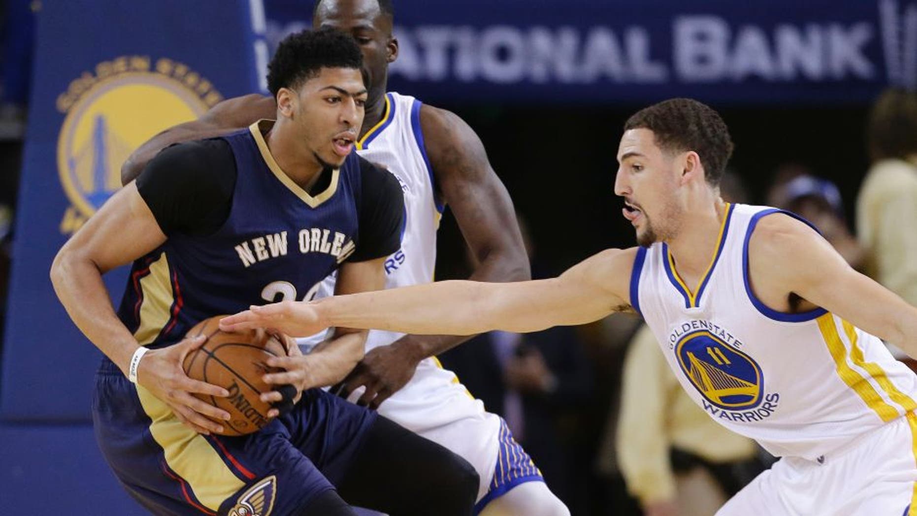 Golden State Warriors' Klay Thompson (11) defends on New Orleans Pelicans' Anthony Davis during the first half in Game 2 of a first-round NBA basketball playoff series Monday, April 20, 2015, in Oakland, Calif. (AP Photo/Marcio Jose Sanchez)