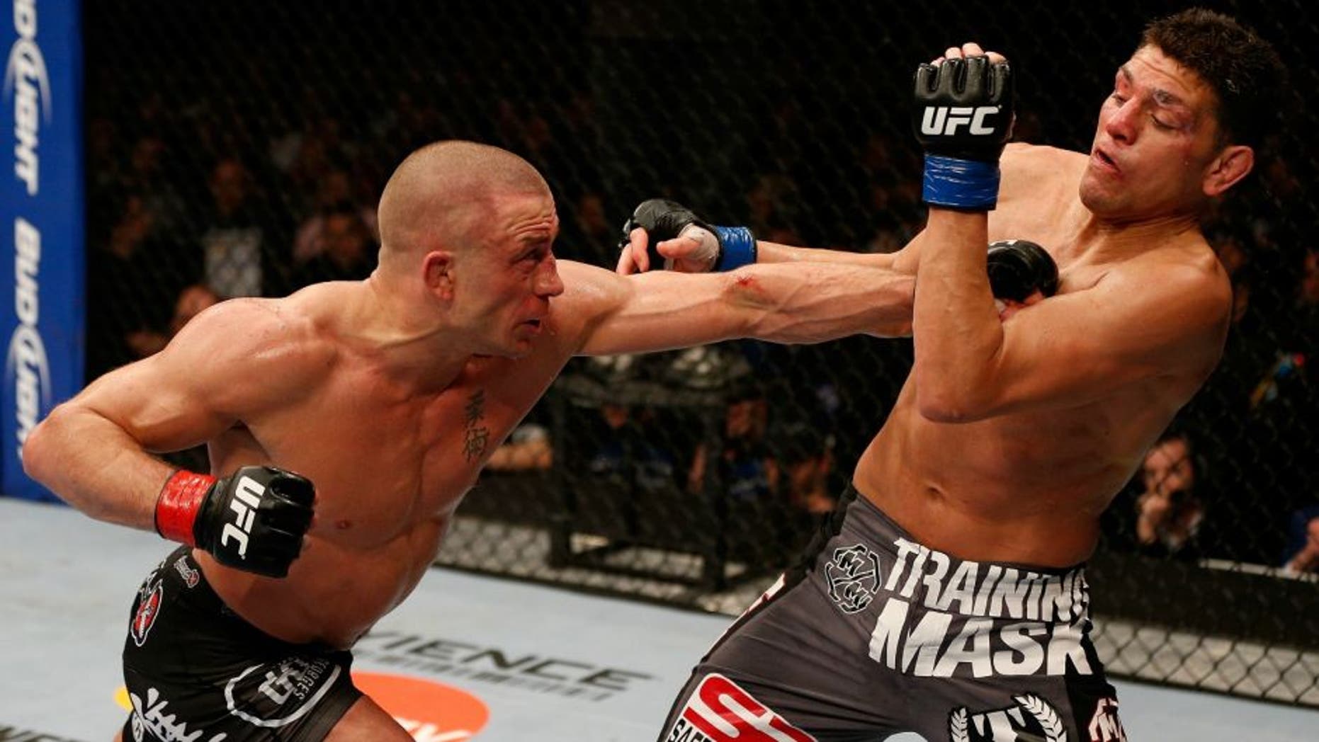 MONTREAL, QC - MARCH 16: (L-R) Georges St-Pierre punches Nick Diaz in their welterweight championship bout during the UFC 158 event at Bell Centre on March 16, 2013 in Montreal, Quebec, Canada. (Photo by Josh Hedges/Zuffa LLC/Zuffa LLC via Getty Images)