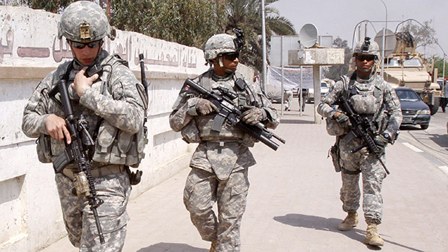 March 23: U.S. troops stand guard outside a local journalists' union office in Basra, Iraq. As the U.S. tries to move from invading power to normal diplomatic partner and the last American troops obligated to be gone by year's end, the protection of American diplomats will fall almost entirely to private contractors and Iraqi security forces.