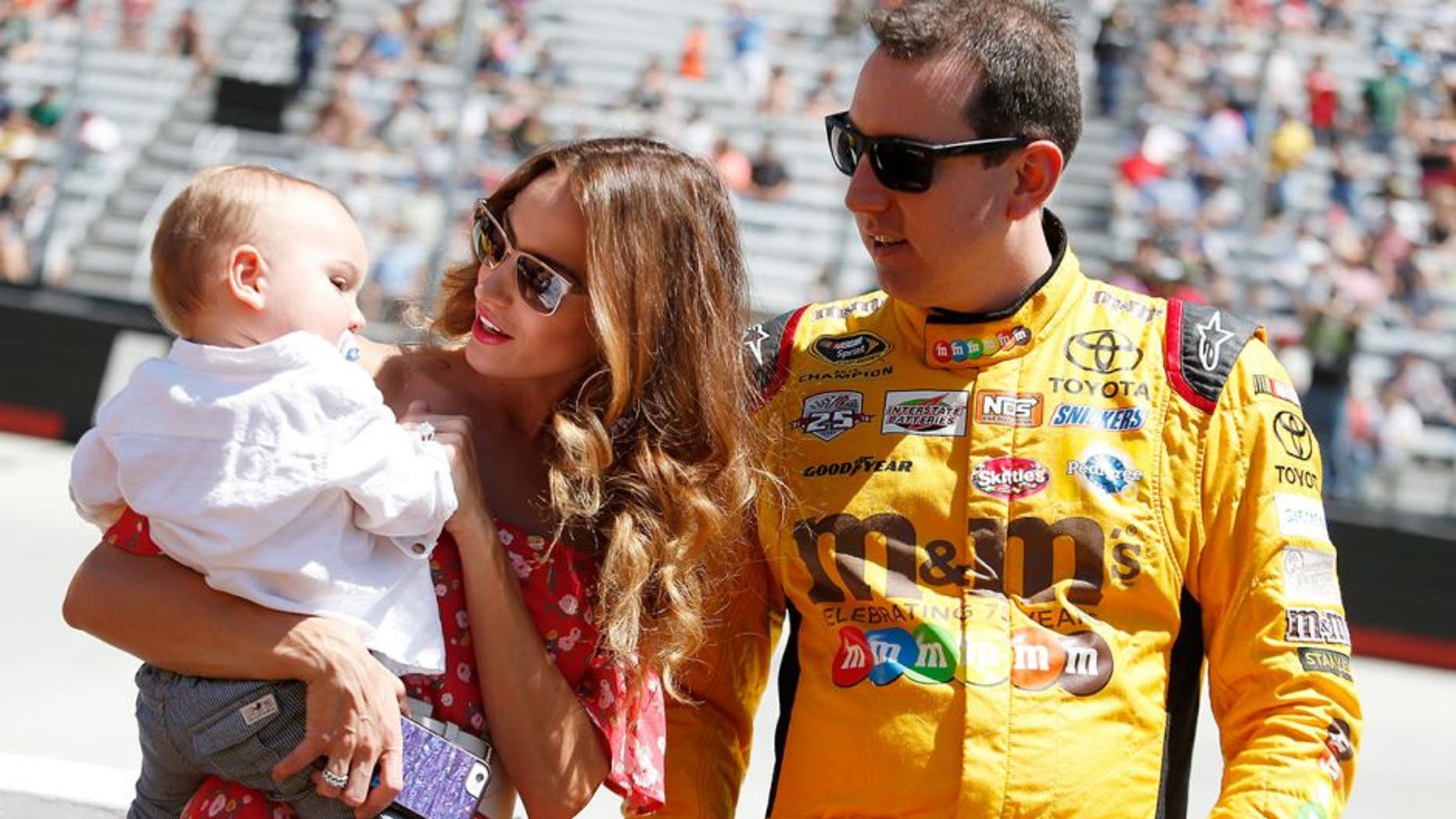 BRISTOL, TN - APRIL 17: Kyle Busch, driver of the #18 M&M's Toyota, stands on the grid with wife Samantha Busch and son Brexton prior to the NASCAR Sprint Cup Series Food City 500 at Bristol Motor Speedway on April 17, 2016 in Bristol, Tennessee. (Photo by Matt Hazlett/Getty Images)