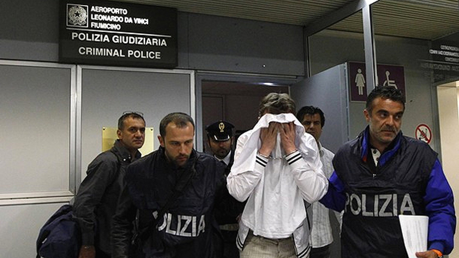 April 25: A man (in white) from Kazakhstan is escorted by police as he leaves Fiumicino airport, northeast Rome. The man, using a knife, tried to hijack an Alitalia flight from Paris to Rome on Sunday night, demanding it be flown to Libya, but was quickly overpowered and arrested when the plane landed, officials and witnesses said.