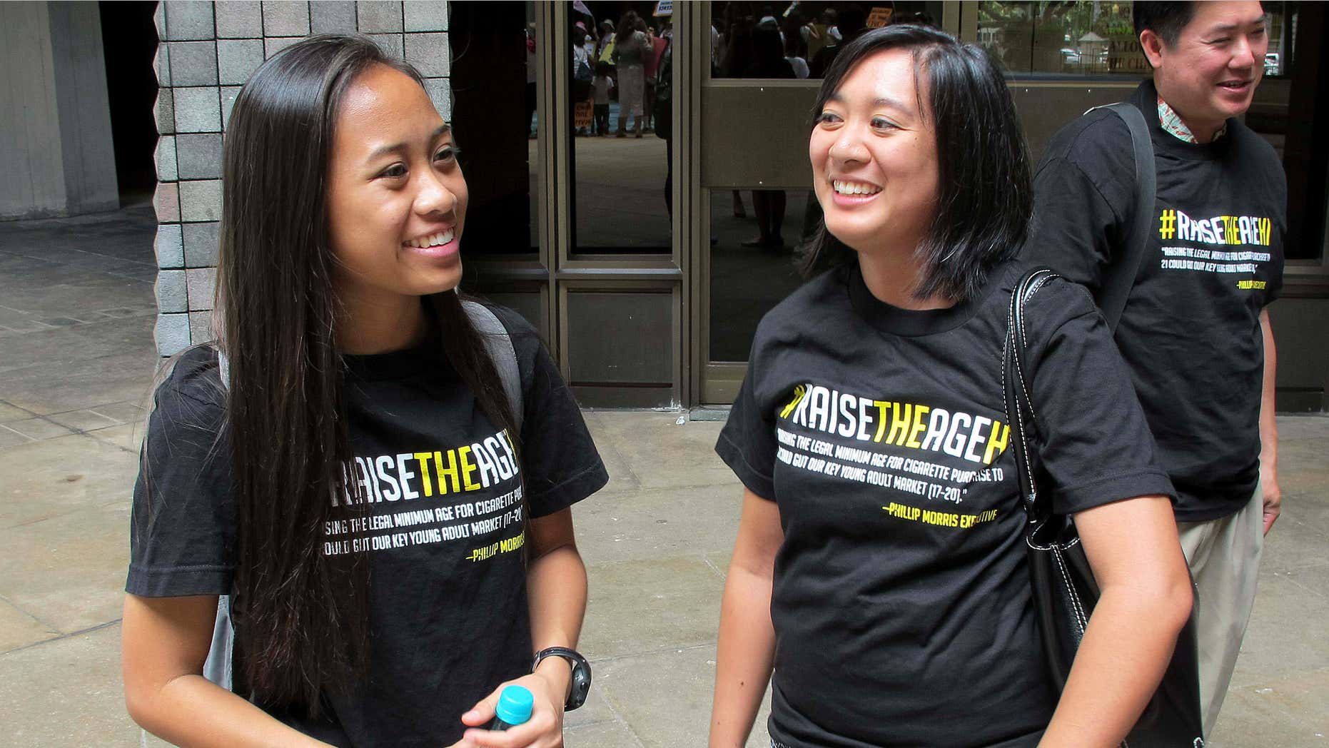 April 24, 2015: Sabrina Olaes, left, a high school senior who supports raising the legal smoking age, reacts with Lyndsey Garcia, center, of the Coalition for a Tobacco-Free Hawaii and Cory Chun of the American Cancer Society Cancer Action Network outside the Hawaii Legislature after it passed a bill to raise the legal smoking age to 21.