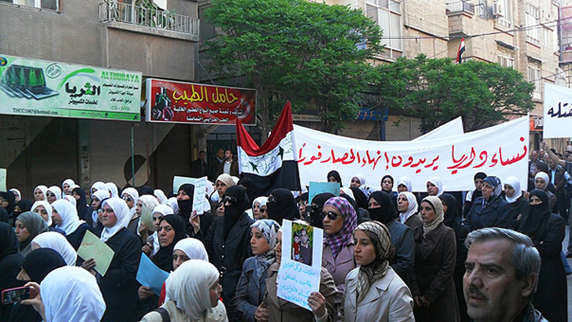 April 25: In this citizen journalism image made on a mobile phone and acquired by the Associated Press, Syrian women carry a banner in Arabic that reads: 'the women of Daraya want an end to the siege,' as they protest in Daraya, southwest of Damascus, Syria.