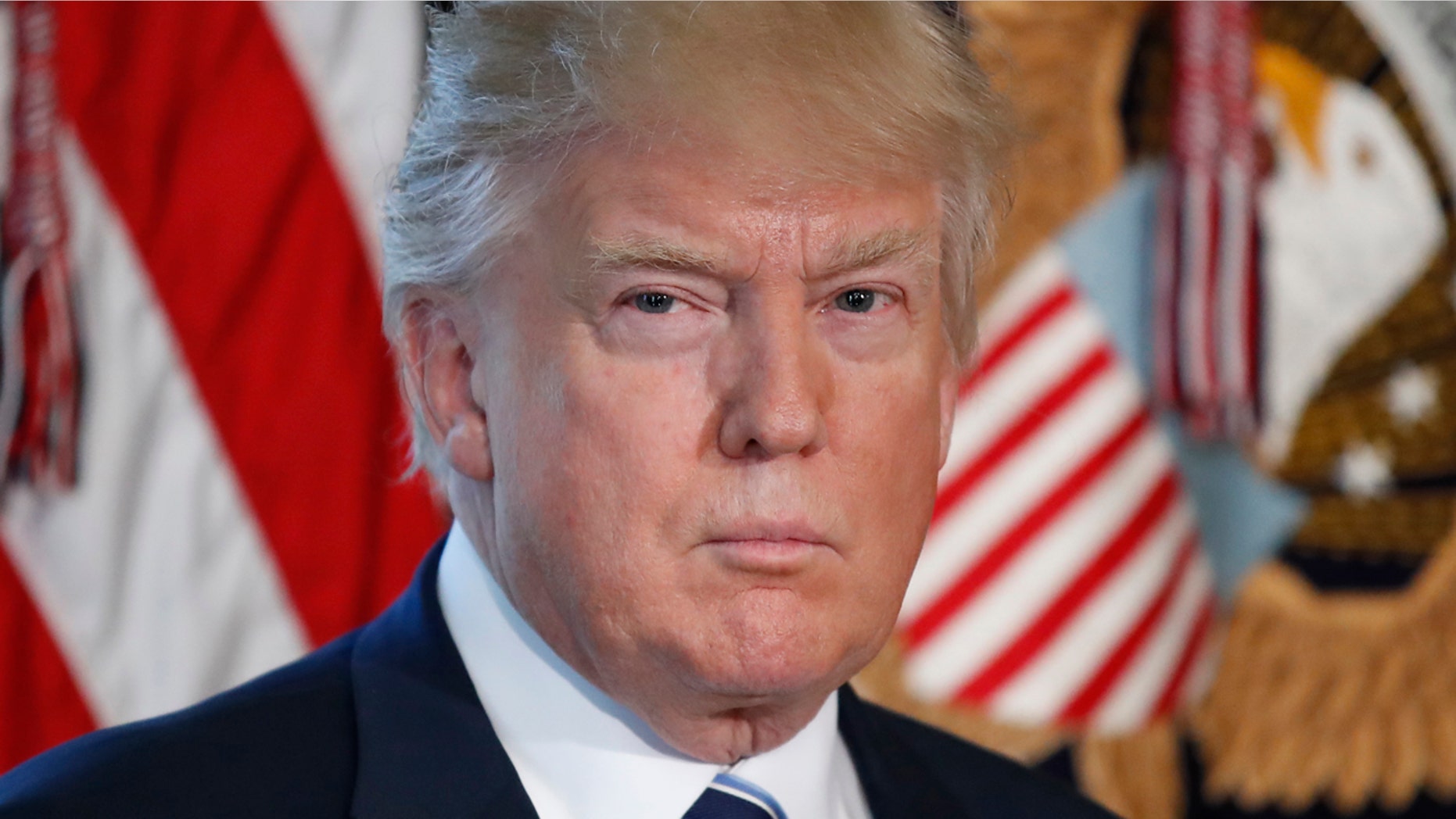 President Donald Trump listens as Treasury Secretary Steve Mnuchin speaks at the Treasury Department in Washington, Friday, April 21, 2017. (AP Photo/Alex Brandon)