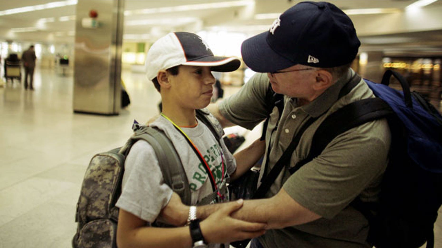 Mhammed, left, says goodbye to National Guard Maj. David Howell, the man who brought him from Iraq to Michigan to treat his childhood injuries, at Baghdad International Airport, Tuesday, April 27, 2010. Mohammed, whose middle and last names are not being publicized, was brought to the U.S. and treated at the Michigan State University hospital thanks to the efforts of a National Guard major who met him in November 2008 in Ramadi, once an insurgent hotbed west of Baghdad. "Be brave," Howell instructed Mohammed before boarding a return flight.
