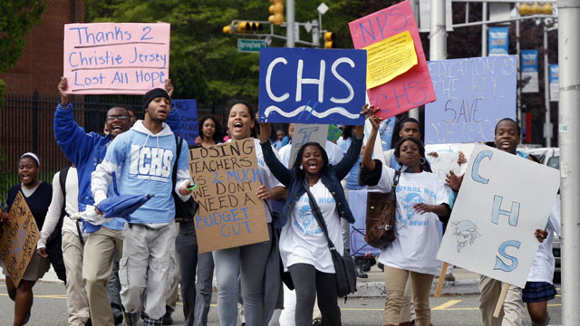 Cental High School students hold signs as they march to administrative offices in Newark, N.J., at about 11 a.m., Tuesday, April 27, 2010, after walking out of classes.