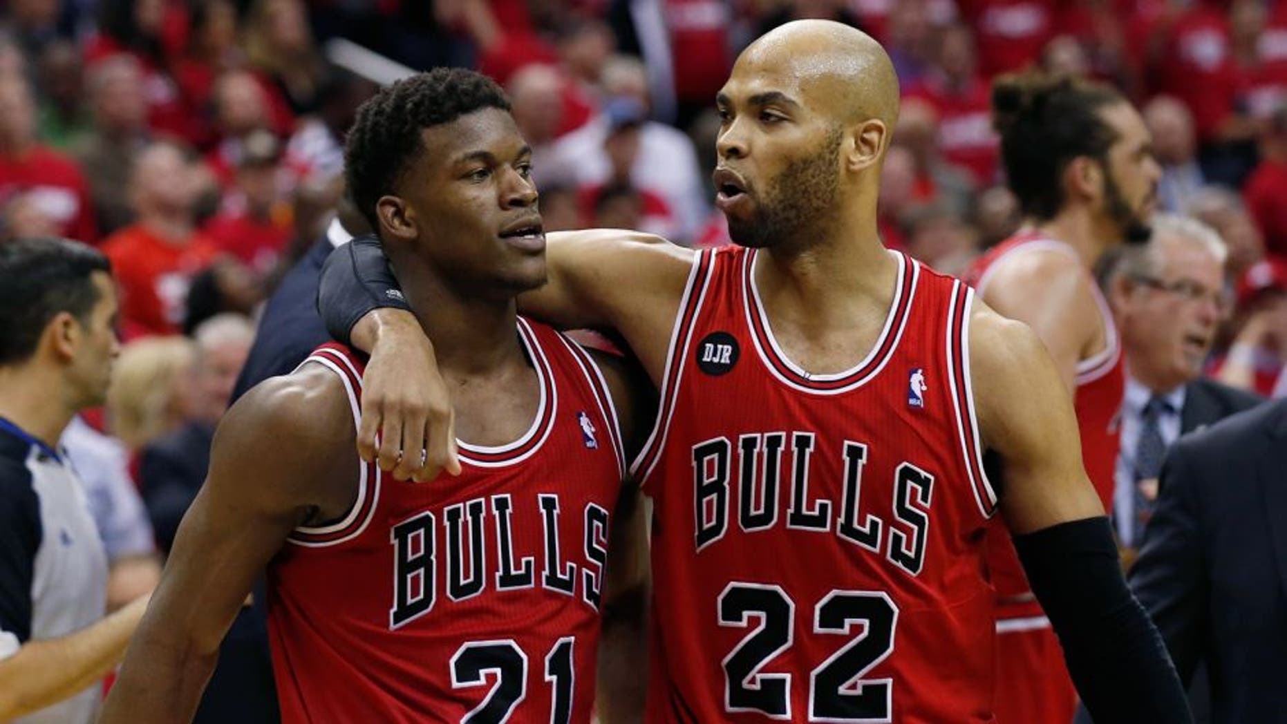 Chicago Bulls guard Jimmy Butler (21) is pulled away by forward Taj Gibson (22) after an altercation with Washington Wizards forward Nene (42), from Brazil, in the second half of Game 3 of an opening-round NBA basketball playoff series on Friday, April 25, 2014, in Washington. Nene received a double technical and was ejected. The Bulls won 100-97. (AP Photo/Alex Brandon)