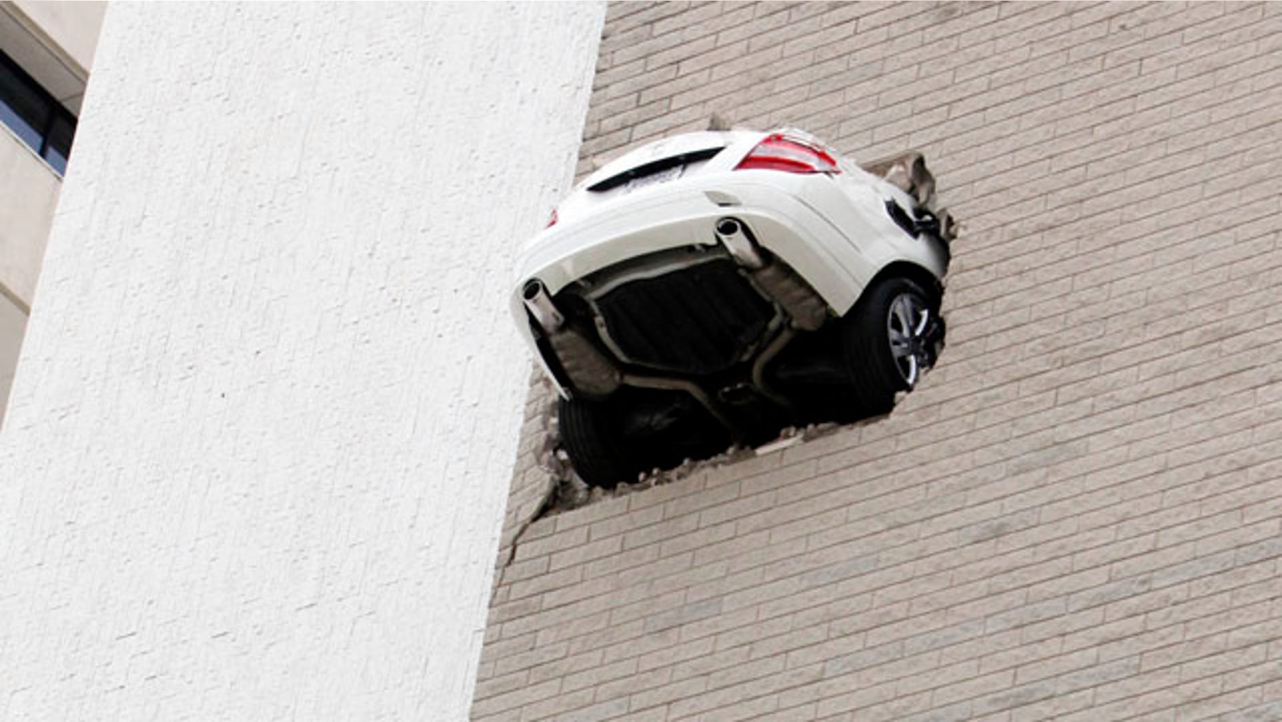 April 28: No injuries were reported when the car seen here went through the 6th floor wall of a parking garage in Tulsa, Okla.
