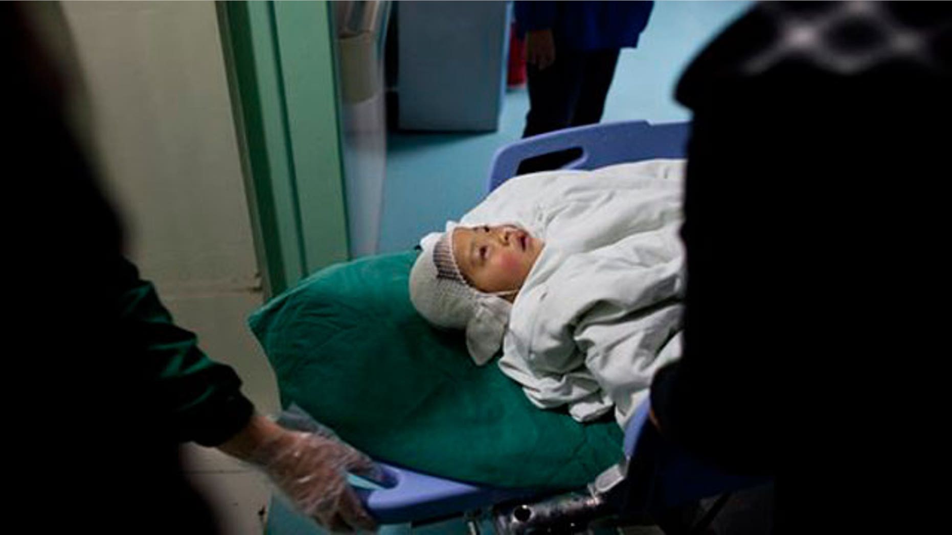 April 29: A child who was attacked at the Zhongxin Kindergarten is transferred into a hospital ward in east China's Jiangsu Province.