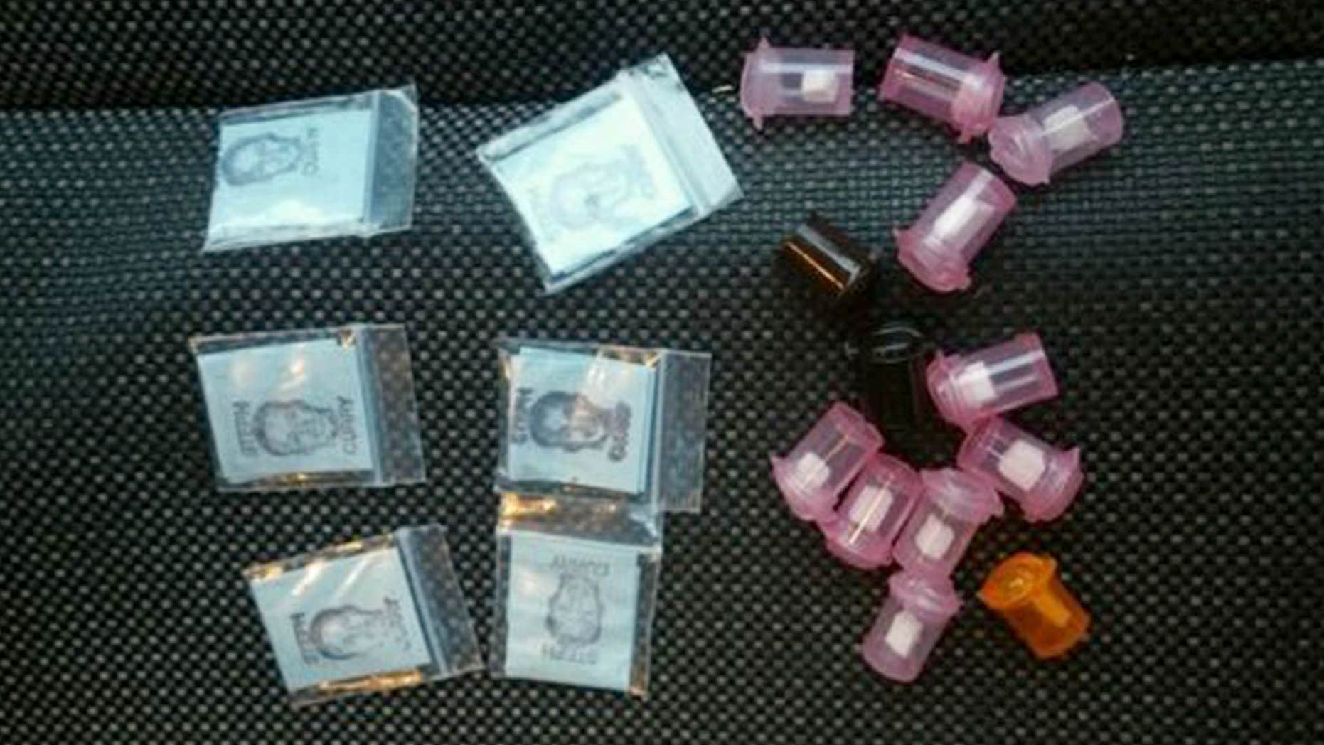 This undated photo provided by the Southeastern Pennsylvania Transportation Authority's SEPTA Transit Police shows packets and plastic containers of heroin confiscated in Philadelphia, including packets labeled with the name and face of Golden State Warriors basketball player Steph Curry in an attempt to signify the quality of the heroin.