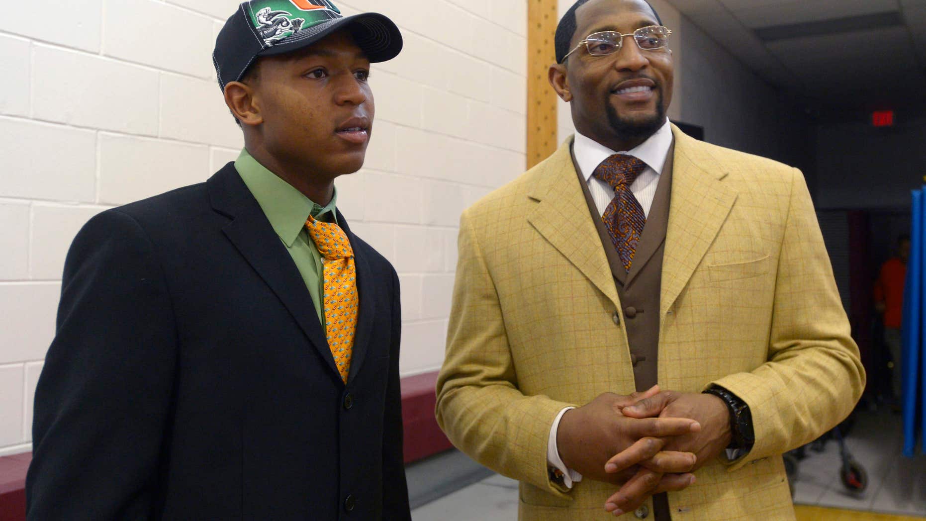 FILE - In this Feb. 6, 2013, file photo, Ray Anthony Lewis III, left, and his father, former Baltimore Ravens linebacker Ray Lewis Jr., chat after his national signing day ceremony in the Lake Mary Prep auditorium in Lake Mary, Fla.