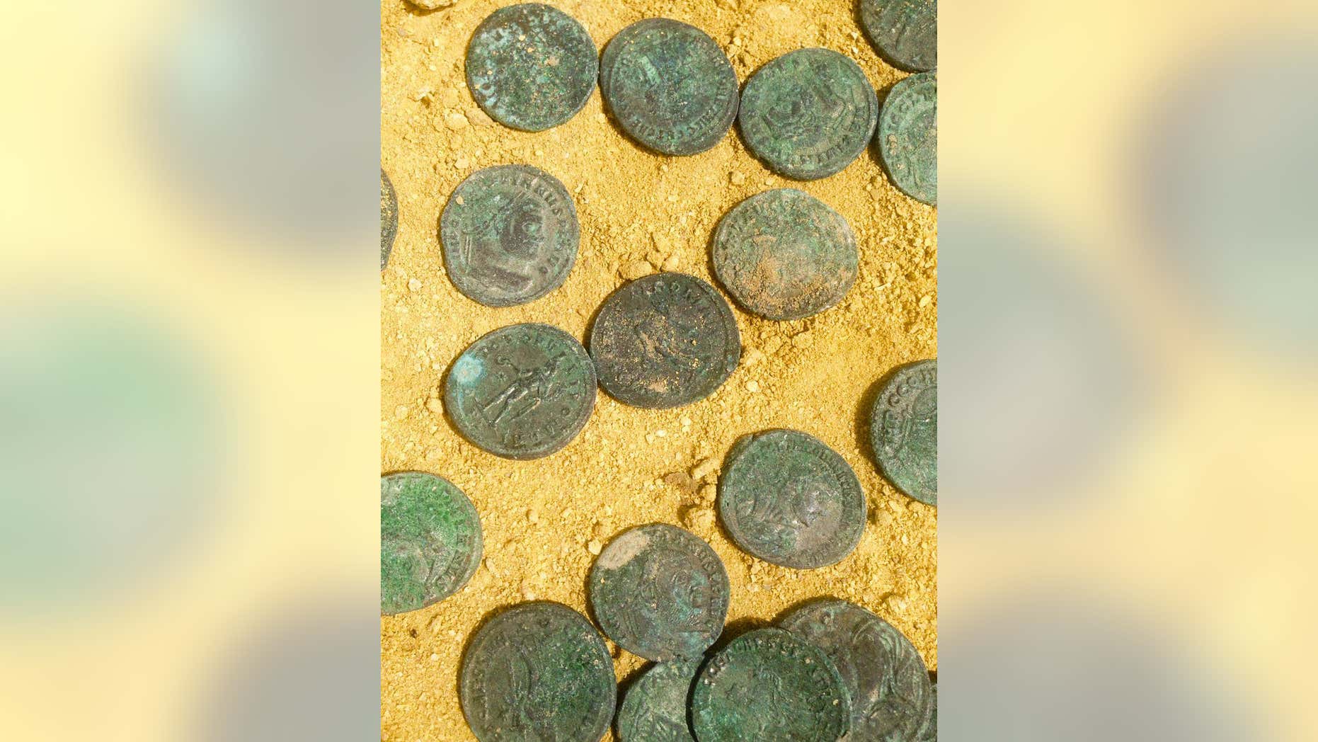 This photo made available by the City Council of Tomares on Friday, April 29, 2016, shows some of the bronze and silver-coated coins dating from the end of the 4th century Workers laying pipes in a southern Spanish park have unearthed a 600-kilogram (1,300-pound) trove of Roman coins in what culture officials say is a unique historic discovery. (City Council of Tomares via AP)