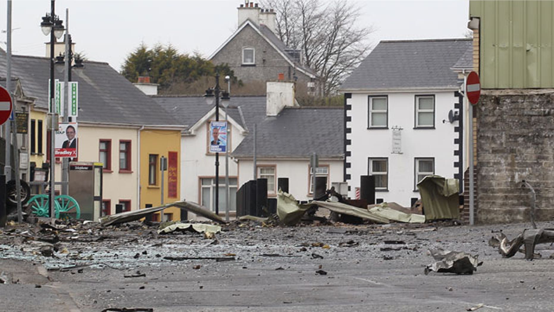 Wreckage lies across the street from car bomb outside Newtownhamilton Police Station, Northern Ireland, Friday, April, 23, 2010. Irish Republican Army dissidents fired gunshots and detonated a car bomb outside a security base in a Northern Ireland border village, injuring three people, police said Friday. The attack outside the heavily fortified Newtownhamilton police station is the third in the British territory this year by splinter IRA groups. They oppose Northern Ireland's peace process and the Catholic-Protestant government it forged.