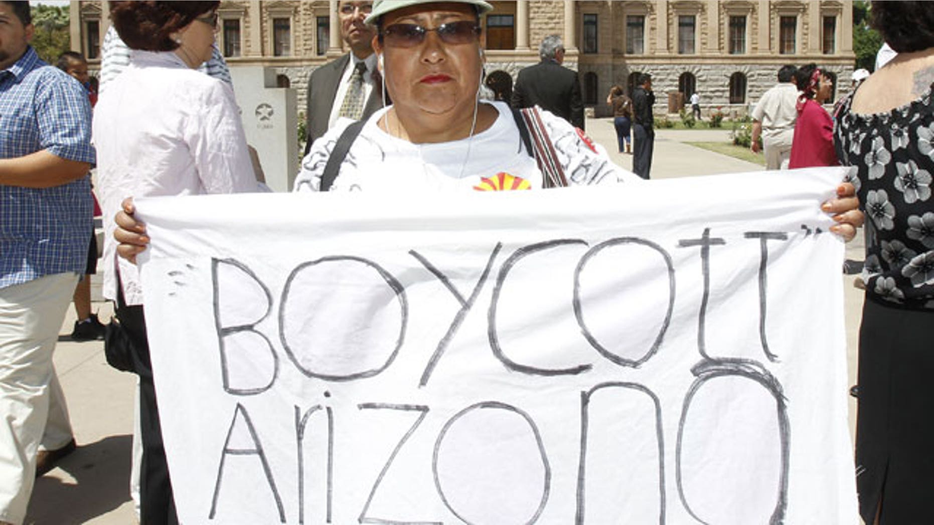 April 29: Josephine Nevarez, of Phoenix, holds a sign in protest as she attends a news conference where it was announced that The National Coalition of Latino Clergy and Christian Leaders, with the support of several other activist groups, had filed a lawsuit seeking an injunction preventing authorities from enforcing the new Arizona immigration law at the Arizona Capitol in Phoenix.