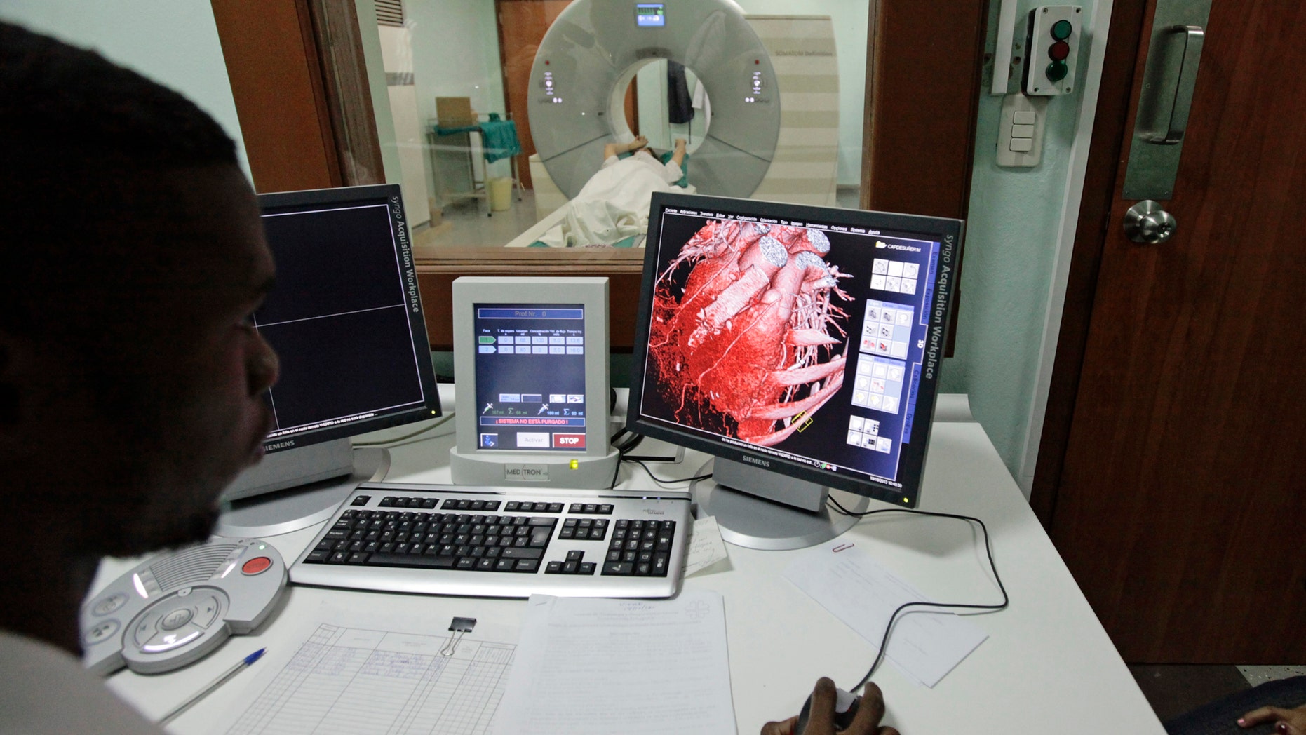 File Photo - A doctor observes a screen showing a graphical representation of a heart of a woman who is lying down during a whole-body scan in the tomography section of Havana's main cardiology and heart surgery hospital October 19, 2012. (REUTERS/Desmond Boylan)
