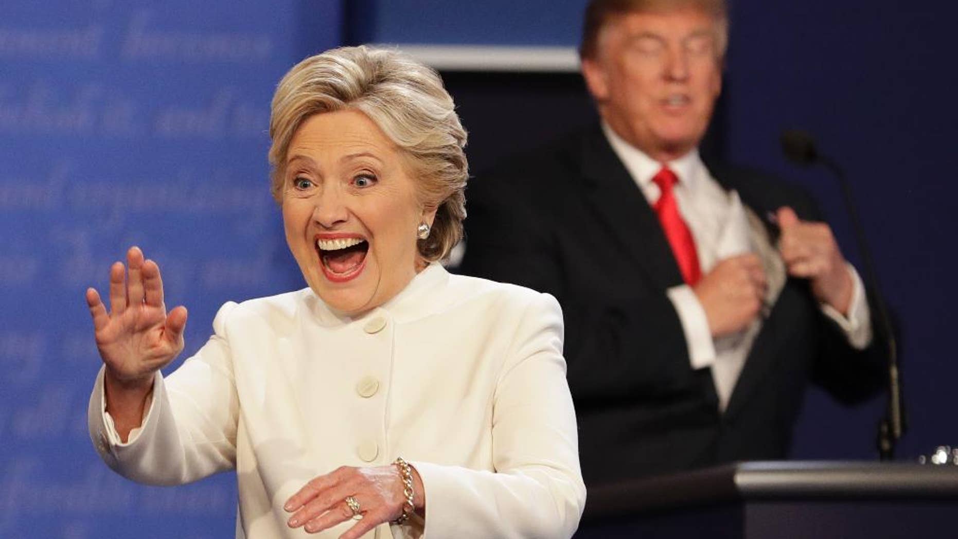 Democratic presidential nominee Hillary Clinton waves to the audience as Republican presidential nominee Donald Trump puts his notes away after the third presidential debate at UNLV in Las Vegas, Wednesday, Oct. 19, 2016. (AP Photo/John Locher)