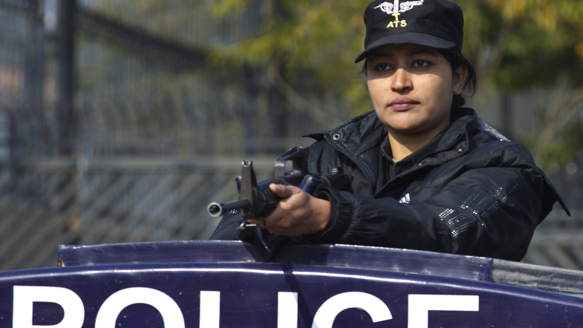A Pakistani female police officer stands alert outside a court set up for the trial of Pakistan's former president and military ruler Pervez Musharraf in Islamabad, Pakistan, Wednesday, Jan. 1, 2014. Musharraf failed to appear in court Wednesday for the second hearing in his high-profile treason case after authorities said they found an explosive device near his home. (AP Photo/B.K. Bangash)