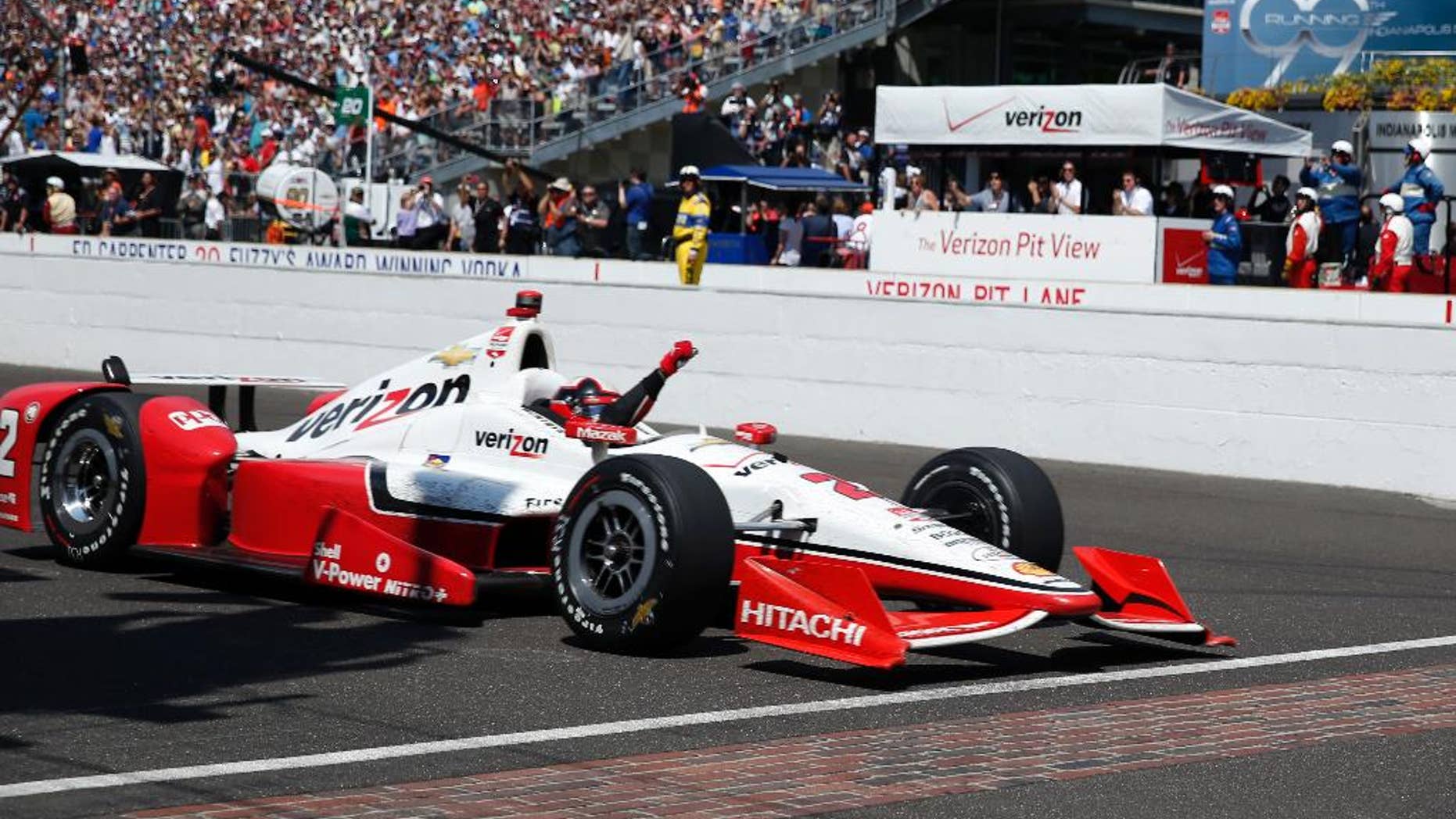 Juan Pablo Montoya, of Colombia, celebrates as he crosses the finish line to win the 99th running of the Indianapolis 500 auto race at Indianapolis Motor Speedway in Indianapolis, Sunday, May 24, 2015. (AP Photo/Rob Baker)