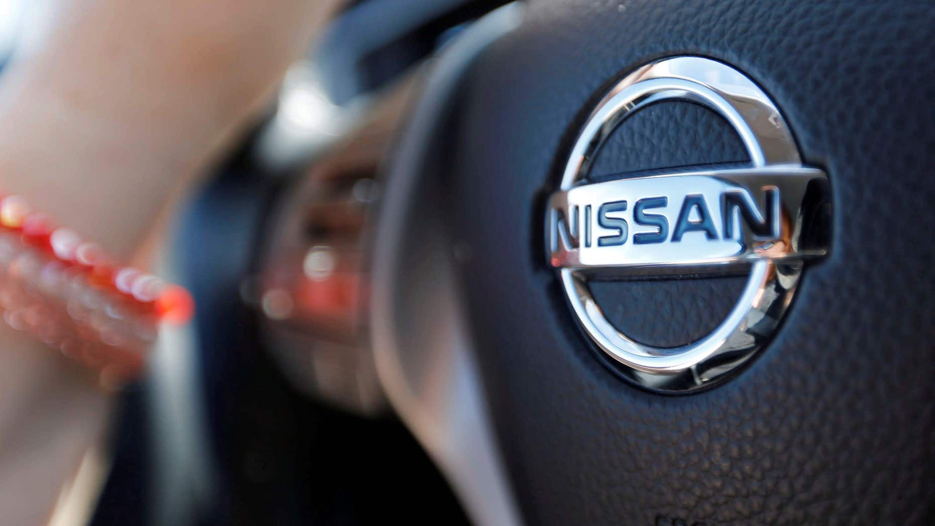 April 23, 2016: A logo of Nissan Motor Co is seen on a steering wheel as a woman drives her car in Golfech, southwestern France.
