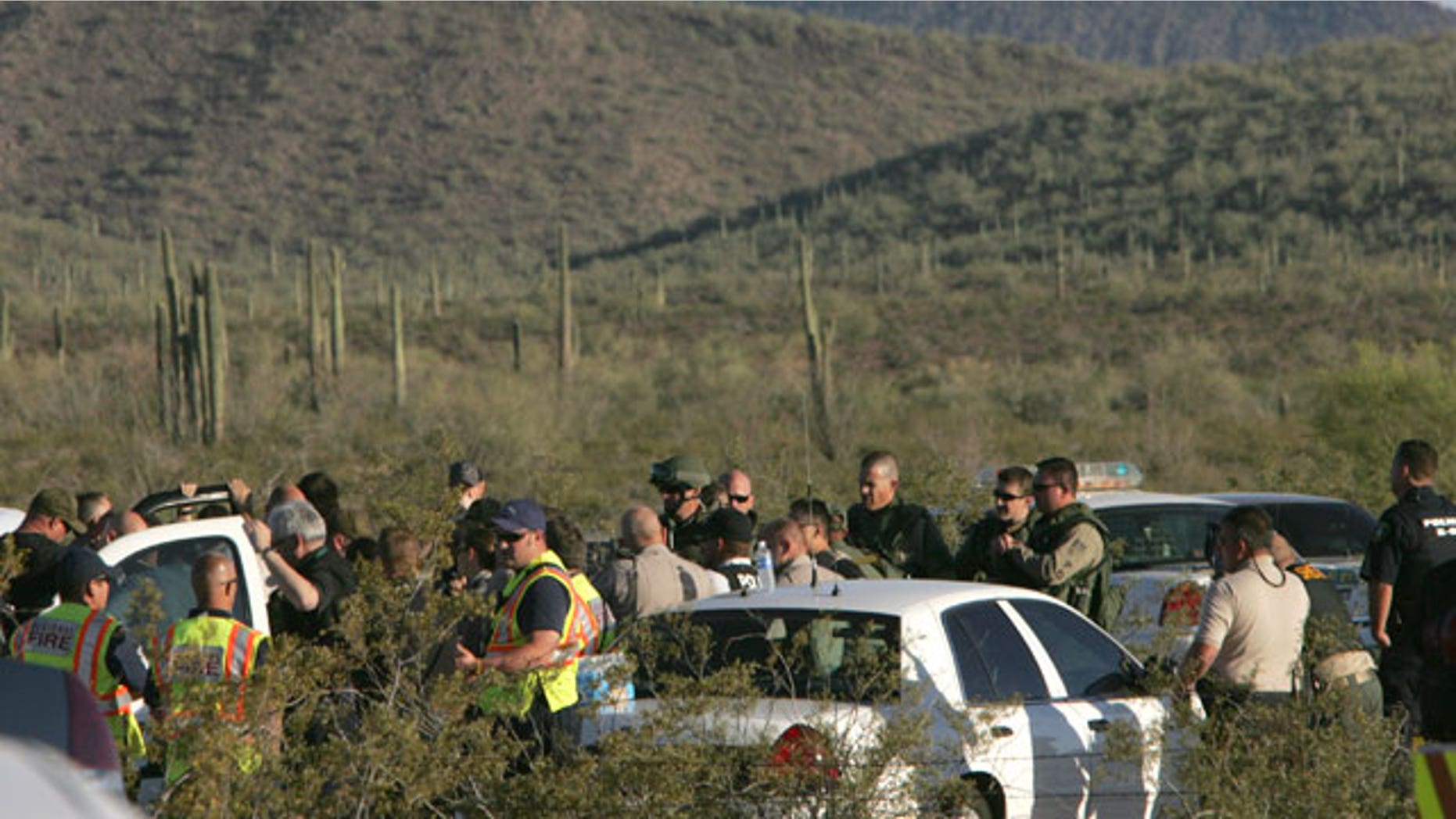 Law enforcement officers from different agencies gather to coordinate the search for a suspect that shot a Pinal County Sheriff's deputy Friday April 30, 2010 in the desert southwest of Stanfield, Ariz. Pinal County sheriff's Lt. Tamatha Villar says the deputy suffered a superficial wound to his abdomen after being shot with an AK-47 assault rifle.