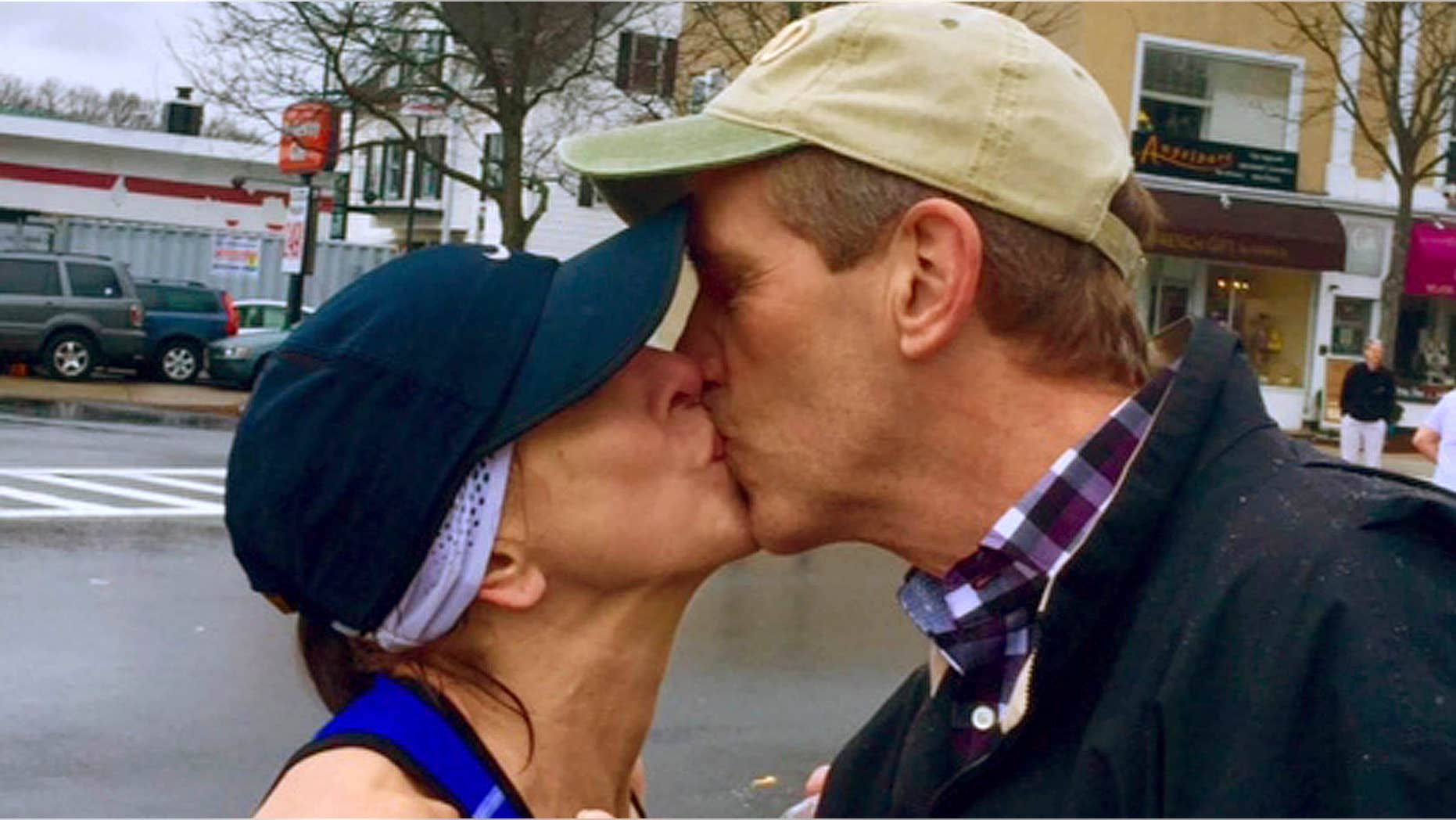 April 20, 2015: In this photo provided by Paige Tatge, her mother, Barbara Tatge, left, kisses an unknown spectator in Wellesley, Mass.