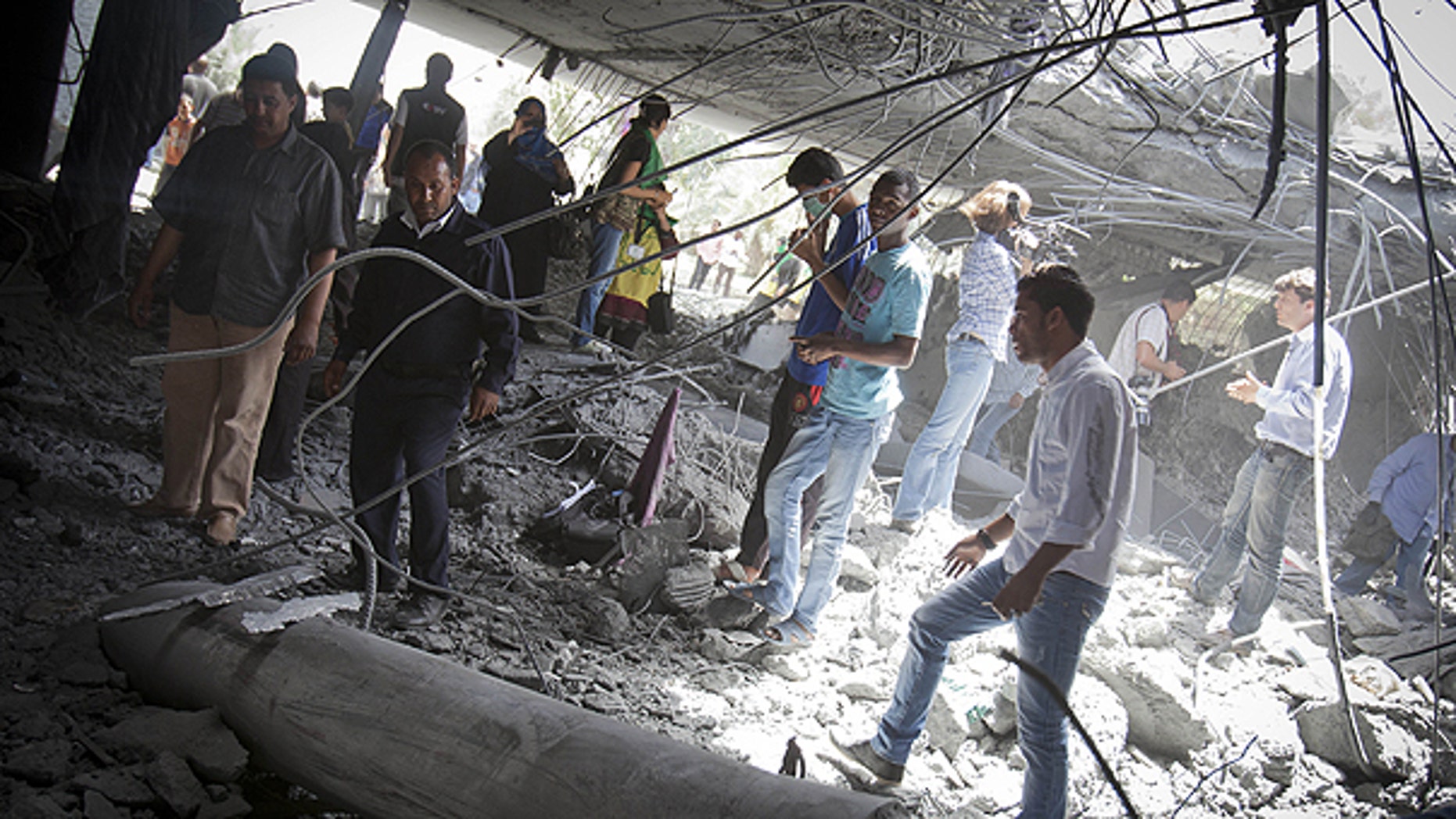 May 1: In this photo made on a government organized tour, supporters inspect damage at the Qaddafi family compound in a residential area of Tripoli, Libya.