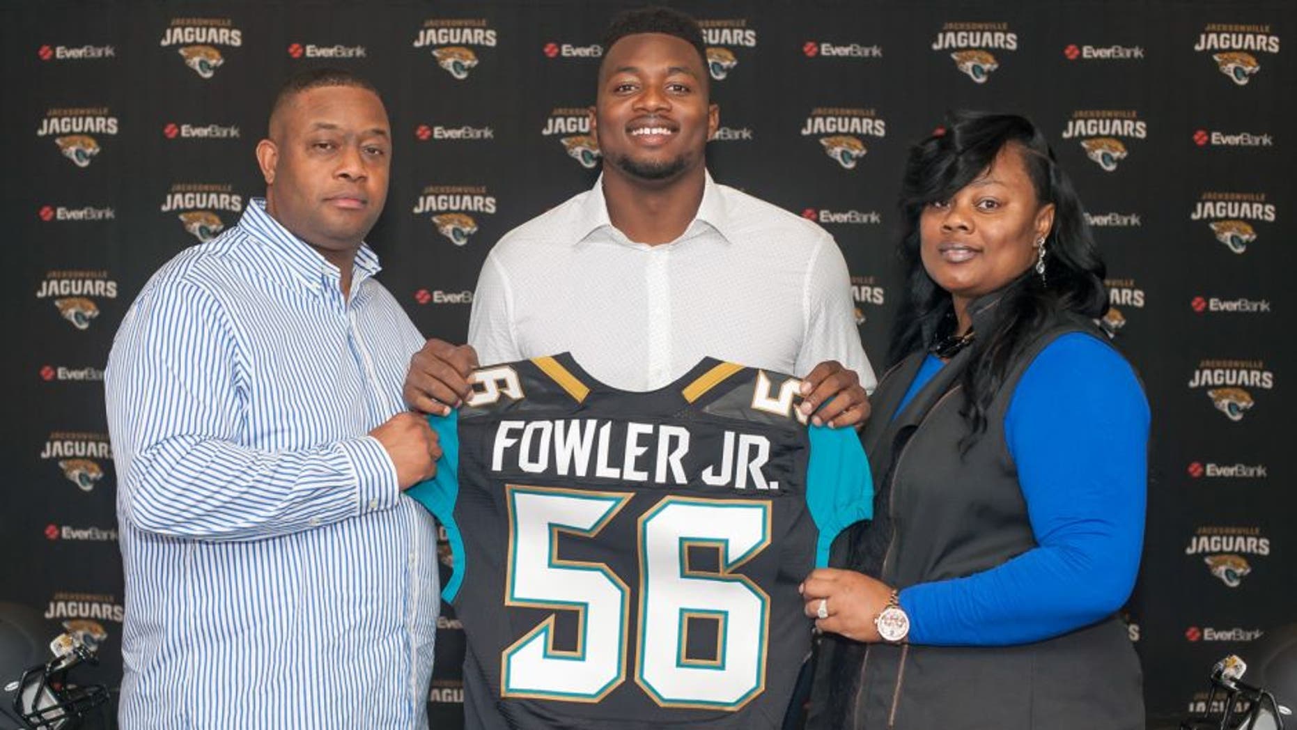 Dante Fowler, cener, the Jacksonville Jaguars first round draft pick, holds up his jersey as he stands between his parents Dante Fowler, Sr. and Lenora Fowler during an NFL football press conference at EverBank Field in Jacksonville, Fla., Saturday May 2, 2015. (Fran Ruchalski/The Florida Times-Union via AP)