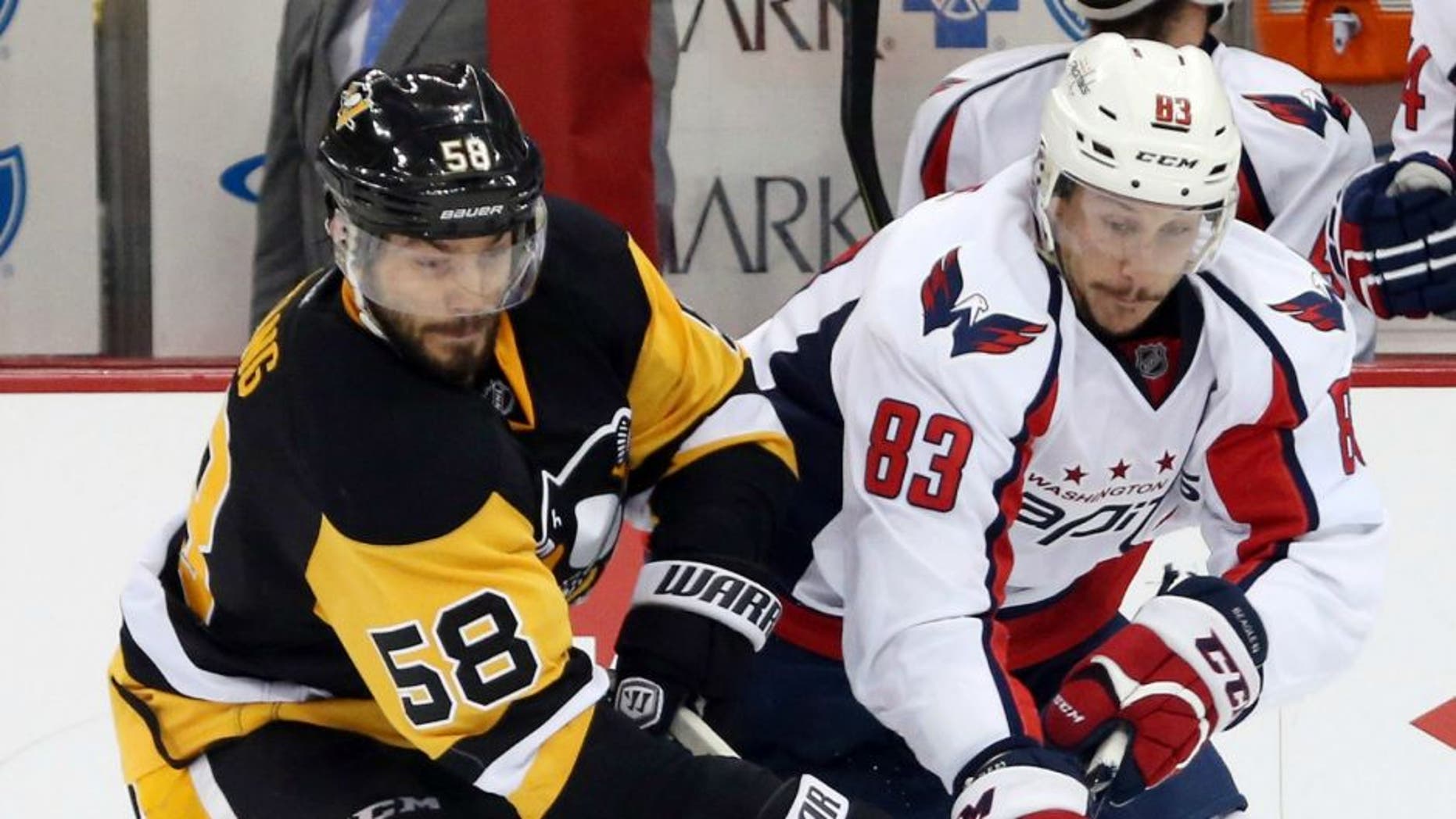 May 2, 2016; Pittsburgh, PA, USA; Pittsburgh Penguins defenseman Kris Letang (58) and Washington Capitals center Jay Beagle (83) chase the puck during the second period in game three of the second round of the 2016 Stanley Cup Playoffs at the CONSOL Energy Center. The Pens won 3-2. Mandatory Credit: Charles LeClaire-USA TODAY Sports