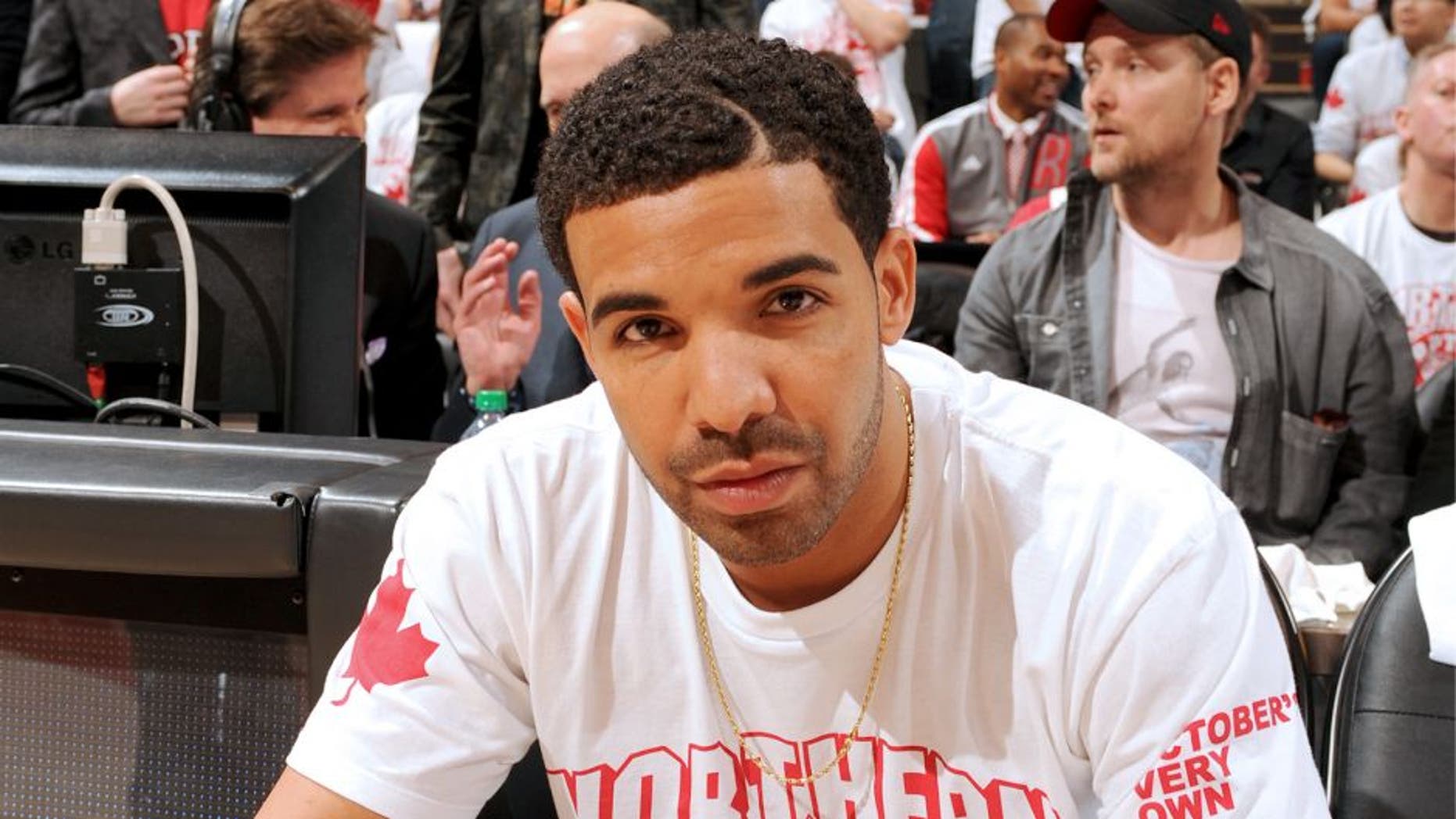 TORONTO, CANADA - April 19: Drake sits on the sideline during Game One of the Eastern Conference Quarterfinals of the 2014 NBA playoffs with the Brooklyn Nets against the Toronto Raptors on April 19, 2014 at the Air Canada Centre in Toronto, Ontario, Canada. NOTE TO USER: User expressly acknowledges and agrees that, by downloading and or using this Photograph, user is consenting to the terms and conditions of the Getty Images License Agreement. Mandatory Copyright Notice: Copyright 2014 NBAE (Photo by Ron Turenne/NBAE via Getty Images)â¨