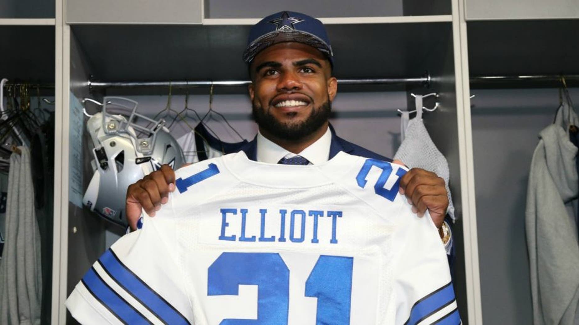 Apr 29, 2016; Irving, TX, USA; Dallas Cowboys number one draft pick Ezekiel Elliott holds his jersey in the locker room at Dallas Cowboys Headquarters Mandatory Credit: Matthew Emmons-USA TODAY Sports