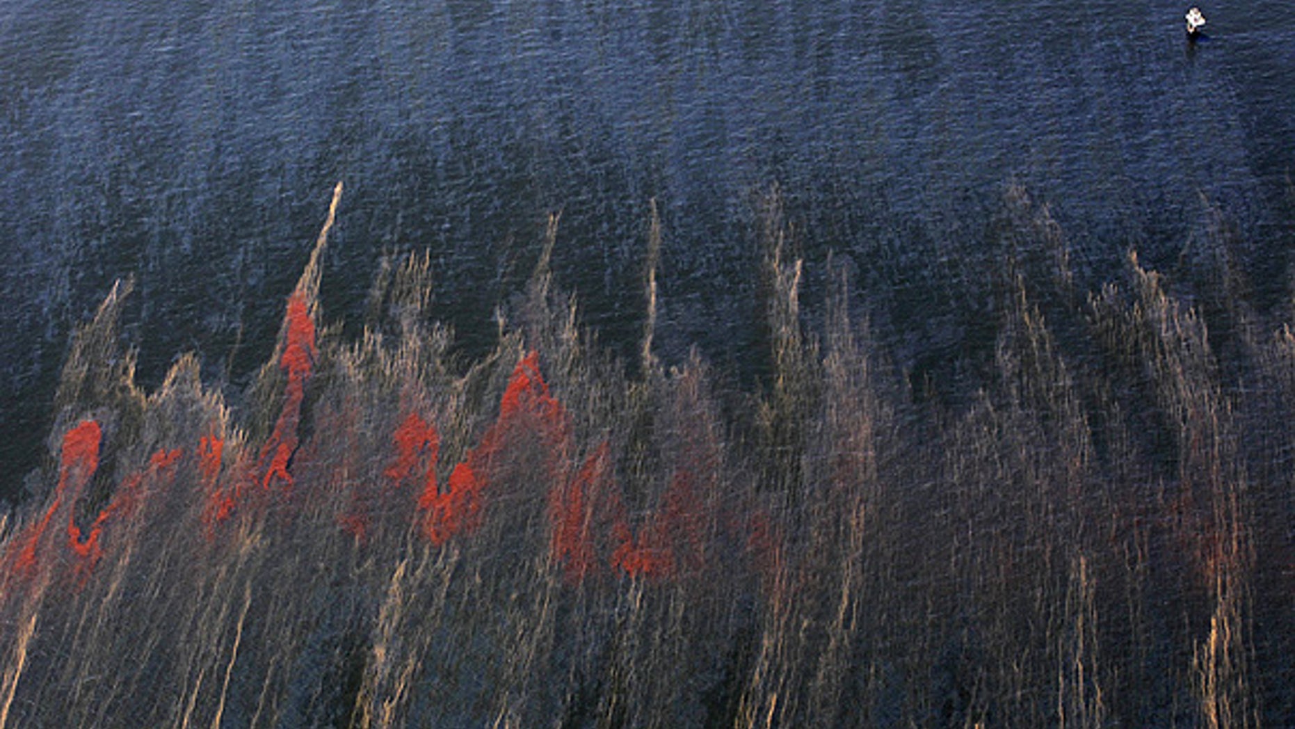 May 5: Oil and sheen are seen moving past a rig, top right, in the waters of Chandeleur Sound, La.