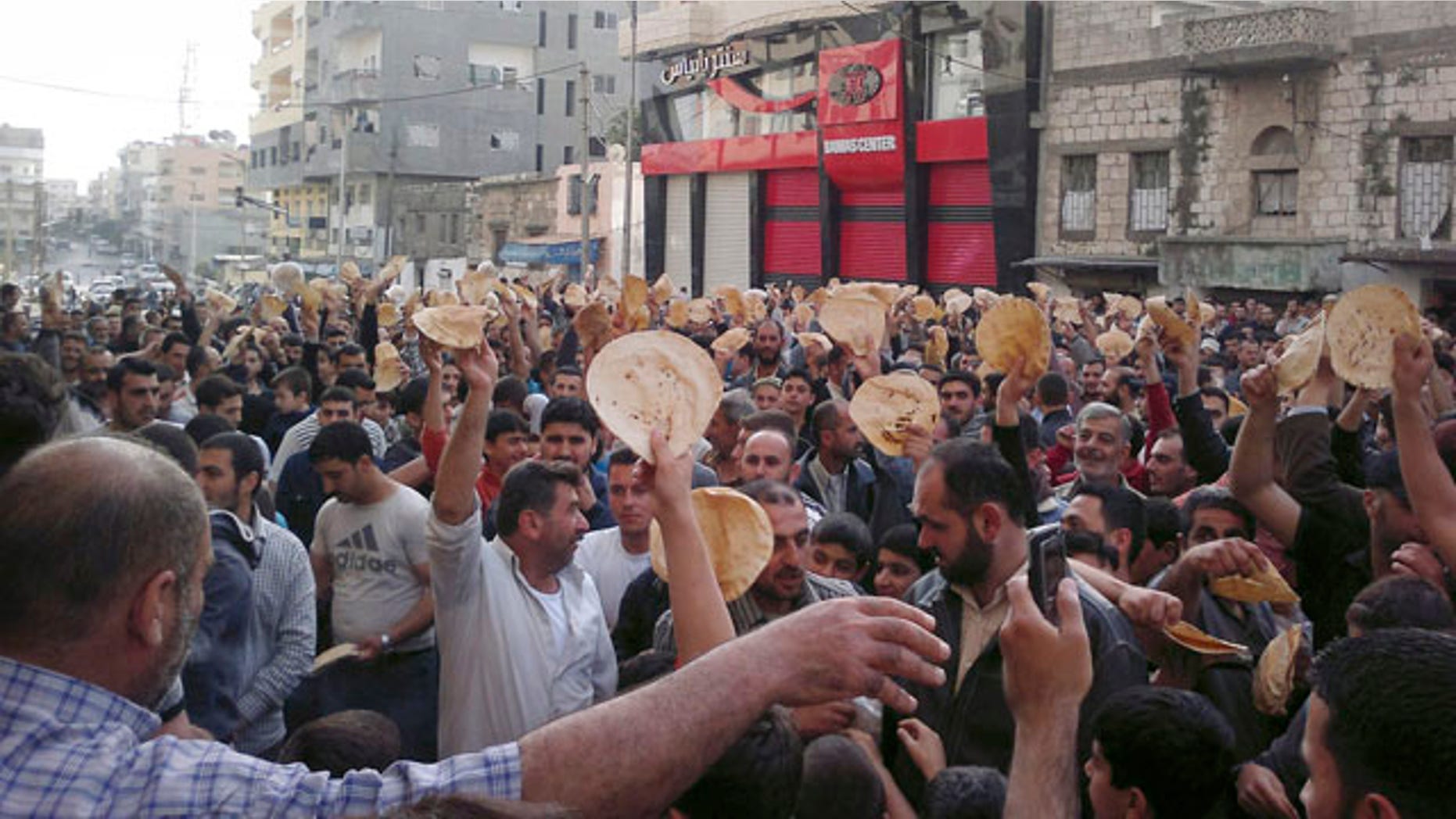 May 3: In this citizen journalism image made on a mobile phone and acquired by the AP, Syrian men carry bread loaves during a protest against Syrian President Bashar Assad's regime in the coastal town of Banias, Syria.