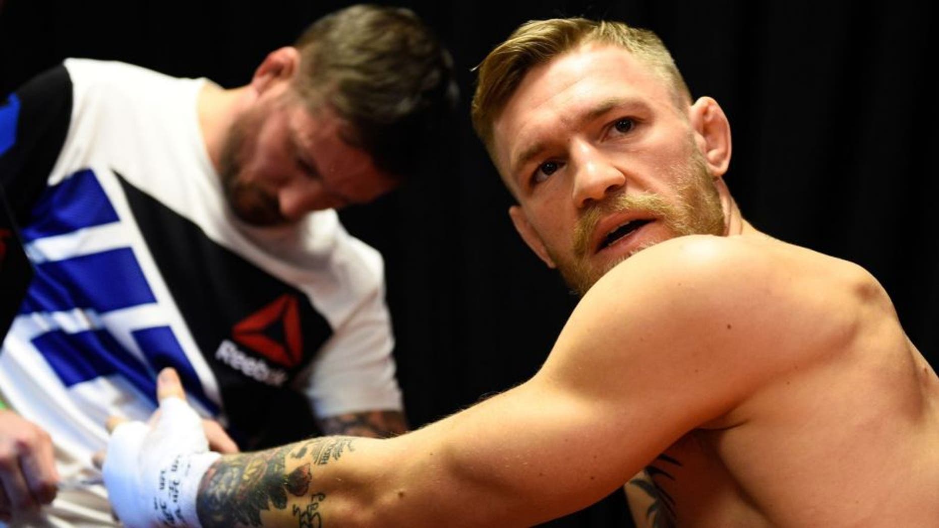 LAS VEGAS, NEVADA - DECEMBER 12: (R-L) Conor McGregor of Ireland gets his hands wrapped by coach John Kavanaugh backstage during the UFC 194 event inside MGM Grand Garden Arena on December 12, 2015 in Las Vegas, Nevada. (Photo by Jeff Bottari/Zuffa LLC/Zuffa LLC via Getty Images)