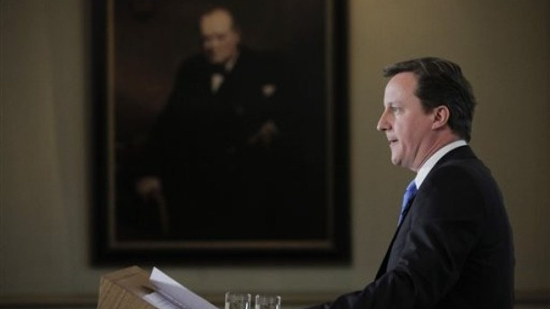 May 7: Britain's Conservatives party leader David Cameron, back dropped by a picture of World War II era British Prime Minister Winston Churchill, reads a statement to members of the media in central London. Cameron, whose Conservatives outpolled ruling Labour party but fell short of winning a majority in Parliament, claimed that voters had rejected Labour in Britain's national election Thursday.