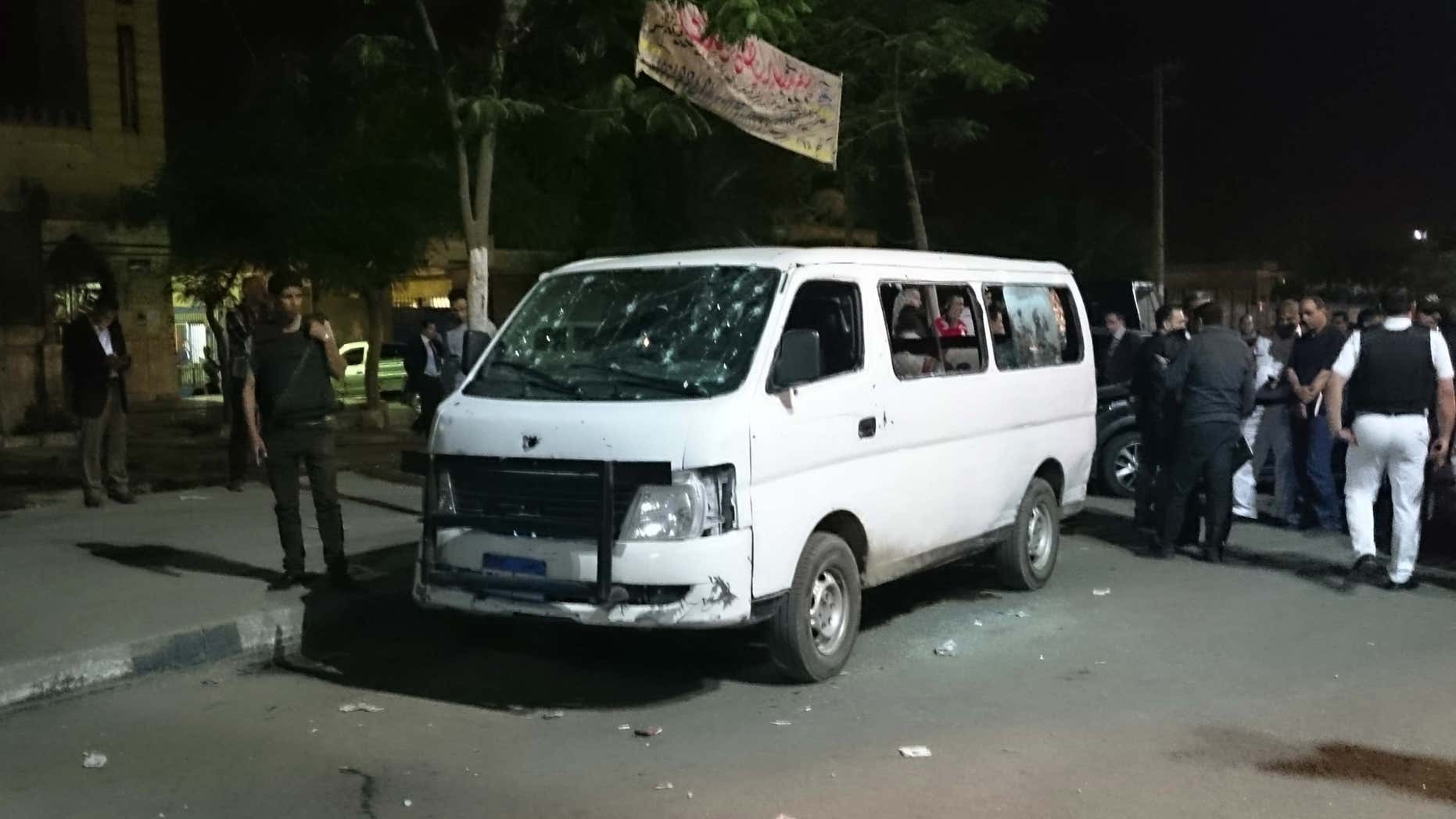 May 8, 2016: Egyptian police and civilians gather around a bullet ridden microbus in the south Cairo neighborhood of Helwan.