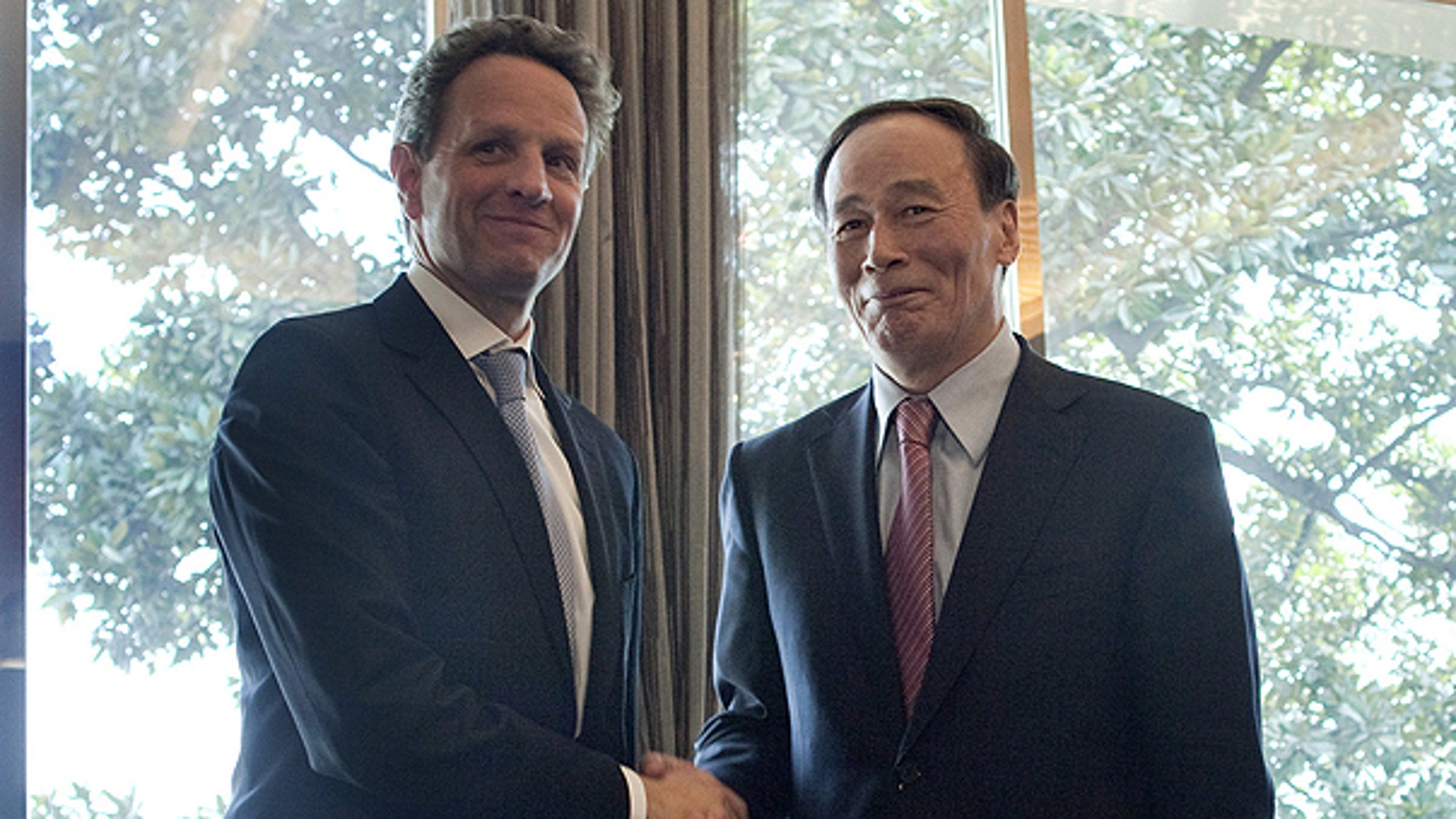 In this March 31, 2011, file photo U.S. Treasury Secretary Timothy Geithner, left, shakes hands with Chinese Vice Premier Wang Qishan prior to having lunch on the sidelines of the G-20 High Level Seminar on the international monetary system in Nanjing, China.