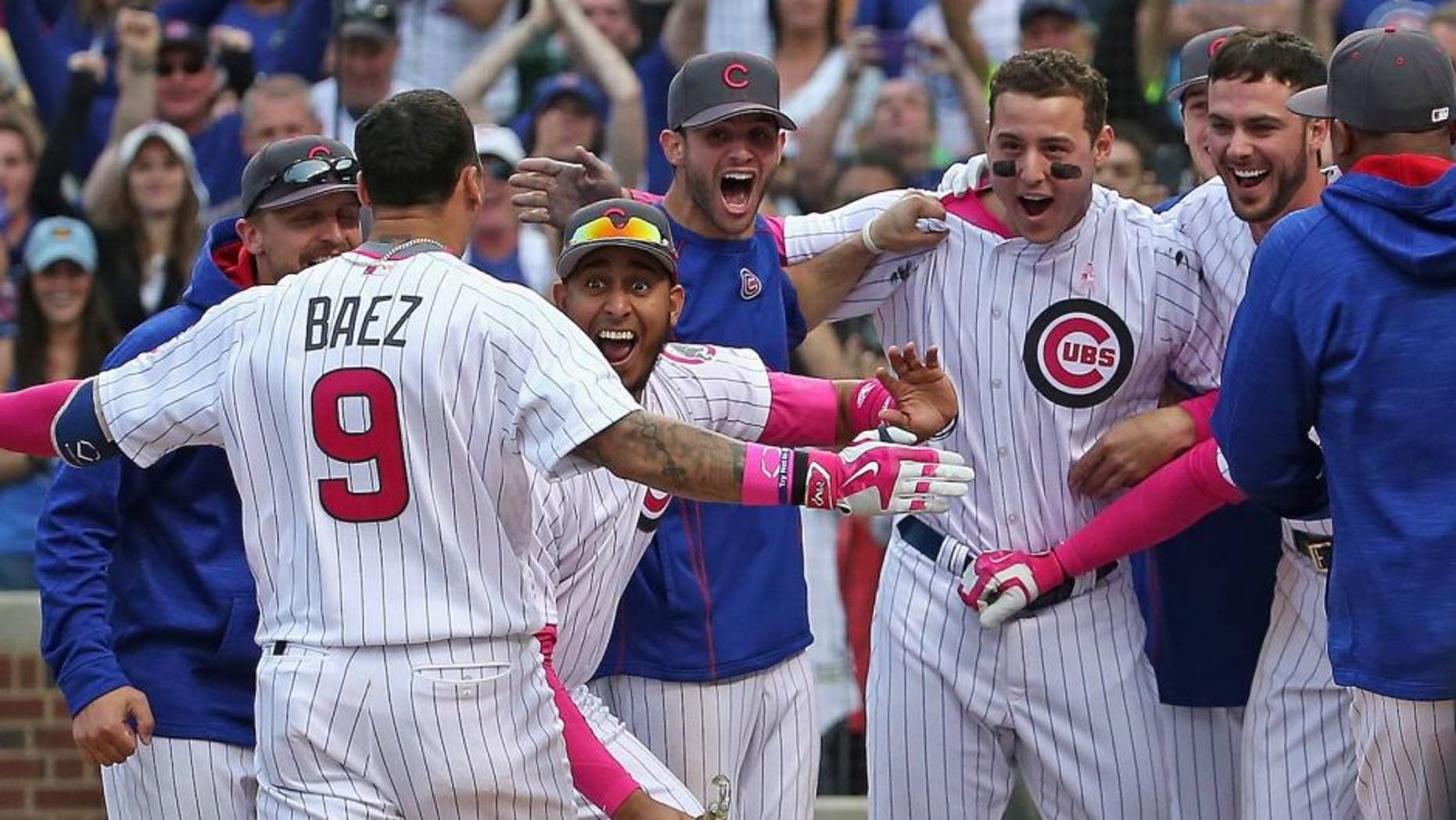 CHICAGO, IL - MAY 08: Javier Baez #9 of the Chicago Cubs is greeted by teammates after hitting the game-winning, walk off home run against the Washington Nationals at Wrigley Field on May 8, 2016 in Chicago, Illinois. The Cubs defeated the Nationals 4-3 in 13 innings. (Photo by Jonathan Daniel/Getty Images)