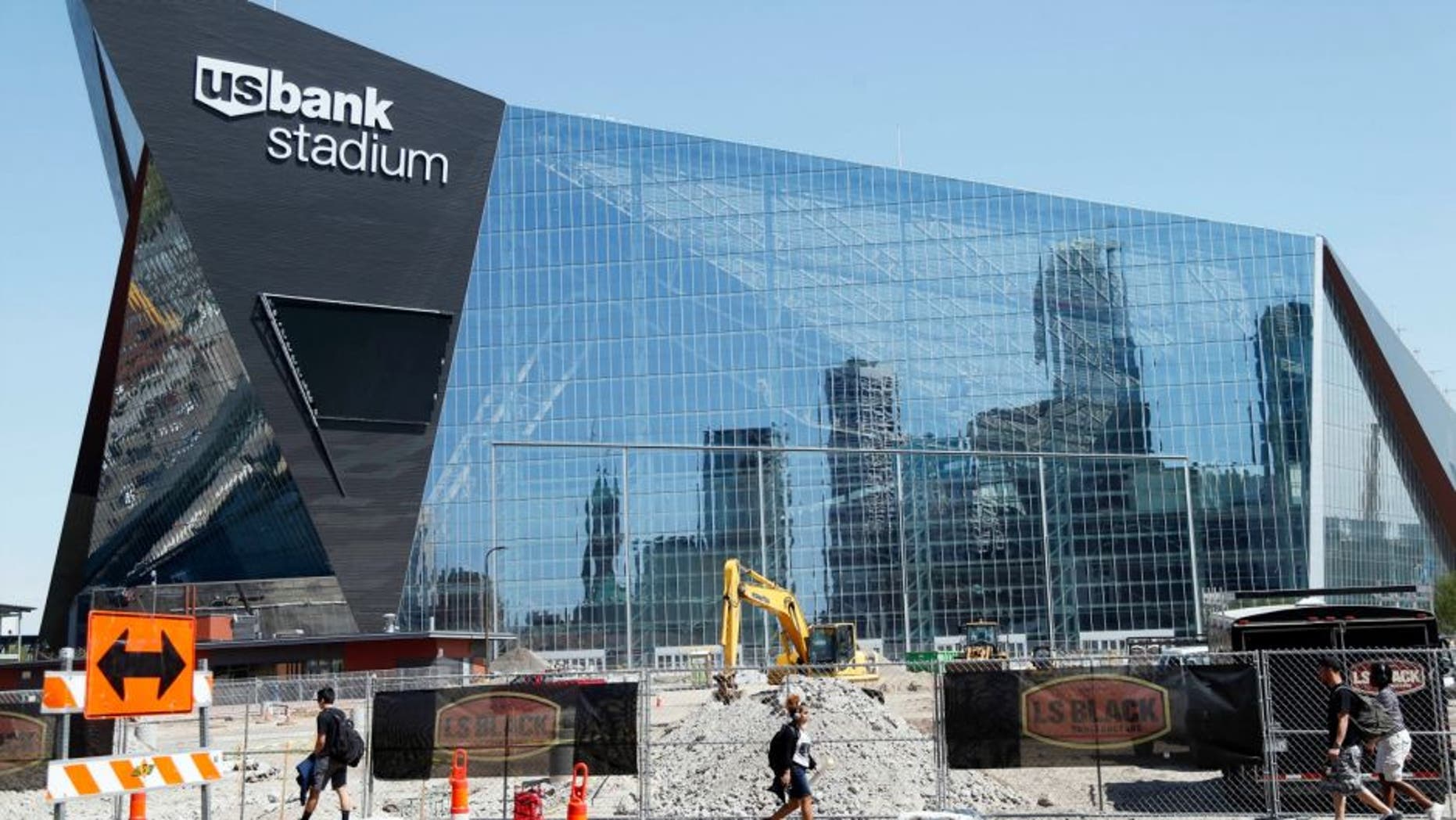 The Minneapolis skyline is reflected in the new U.S. Bank Stadium in Minneapolis as it nears completion for the $1.2 billion home of the Minnesota Vikings NFL football team beginning this season in Minneapolis. (AP Photo/Jim Mone)