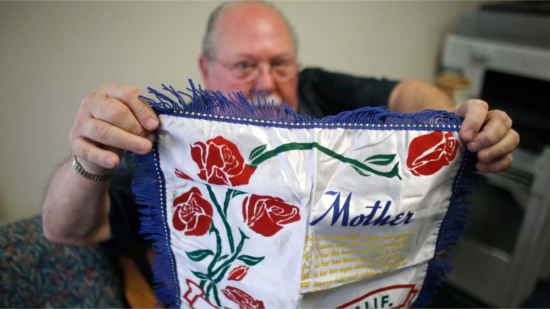 May 5, 2015: Don Lamoureux displays a World War II era pillow sham at a senior center in Millville, Mass., which his son purchased from an online auction site.